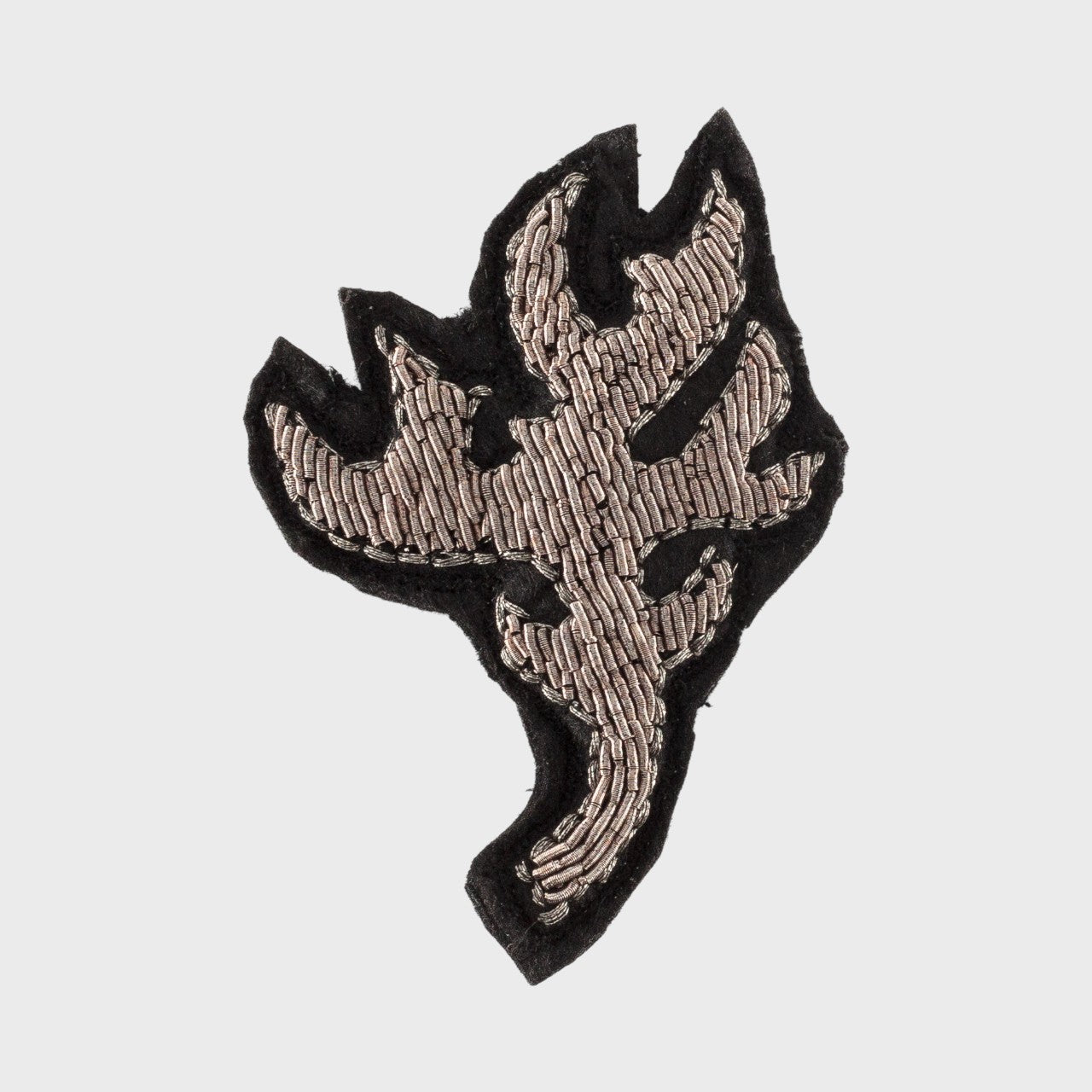 An embroidered brooch representing a silver antler.