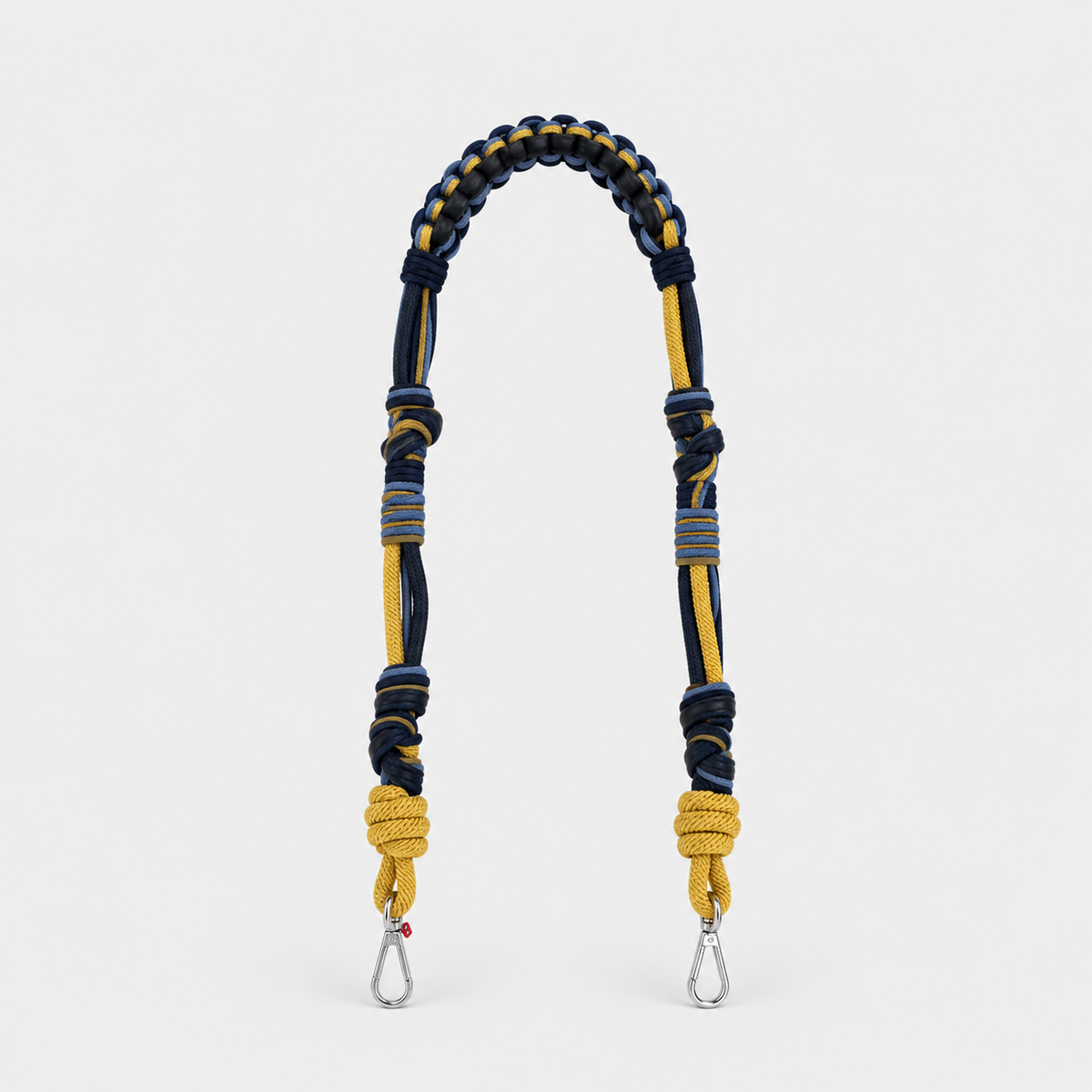A long bag strap with black leather and yellow and blue macramé.