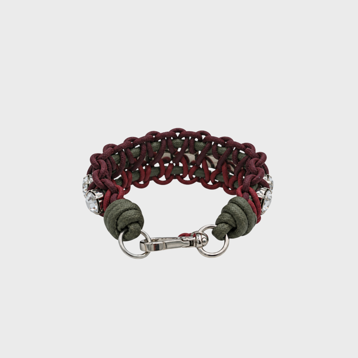 A handmade macramé woven bracelet featuring a mix of brugundy, green and red threads, accented with small white beads and a silver clasp.