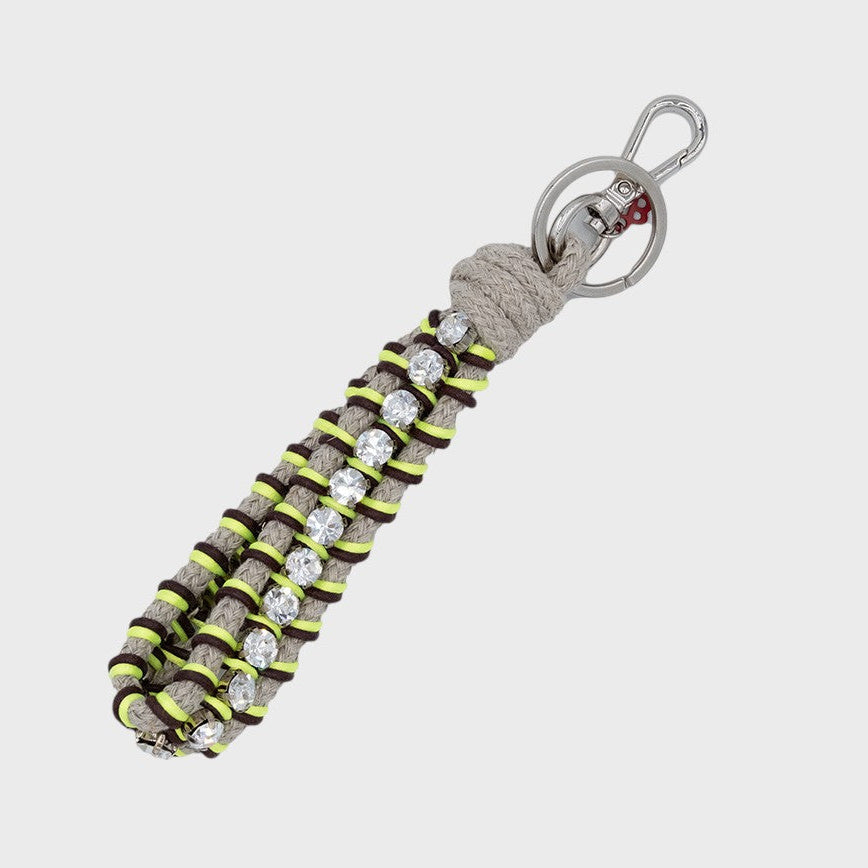 Keychain with gray, brown and neon yellow patterned band and rhinestones on a white background
