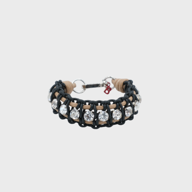 A braided macramé bracelet featuring black and beige cords with small white beads.