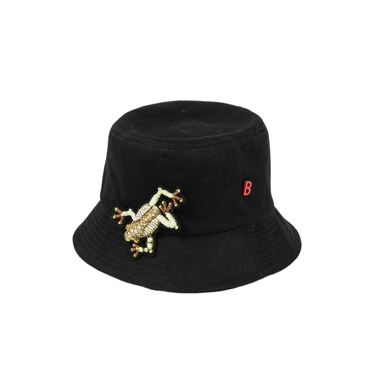 A black cotton bucket hat with a dendrobate embroidered brooch and a red B pinned on it.