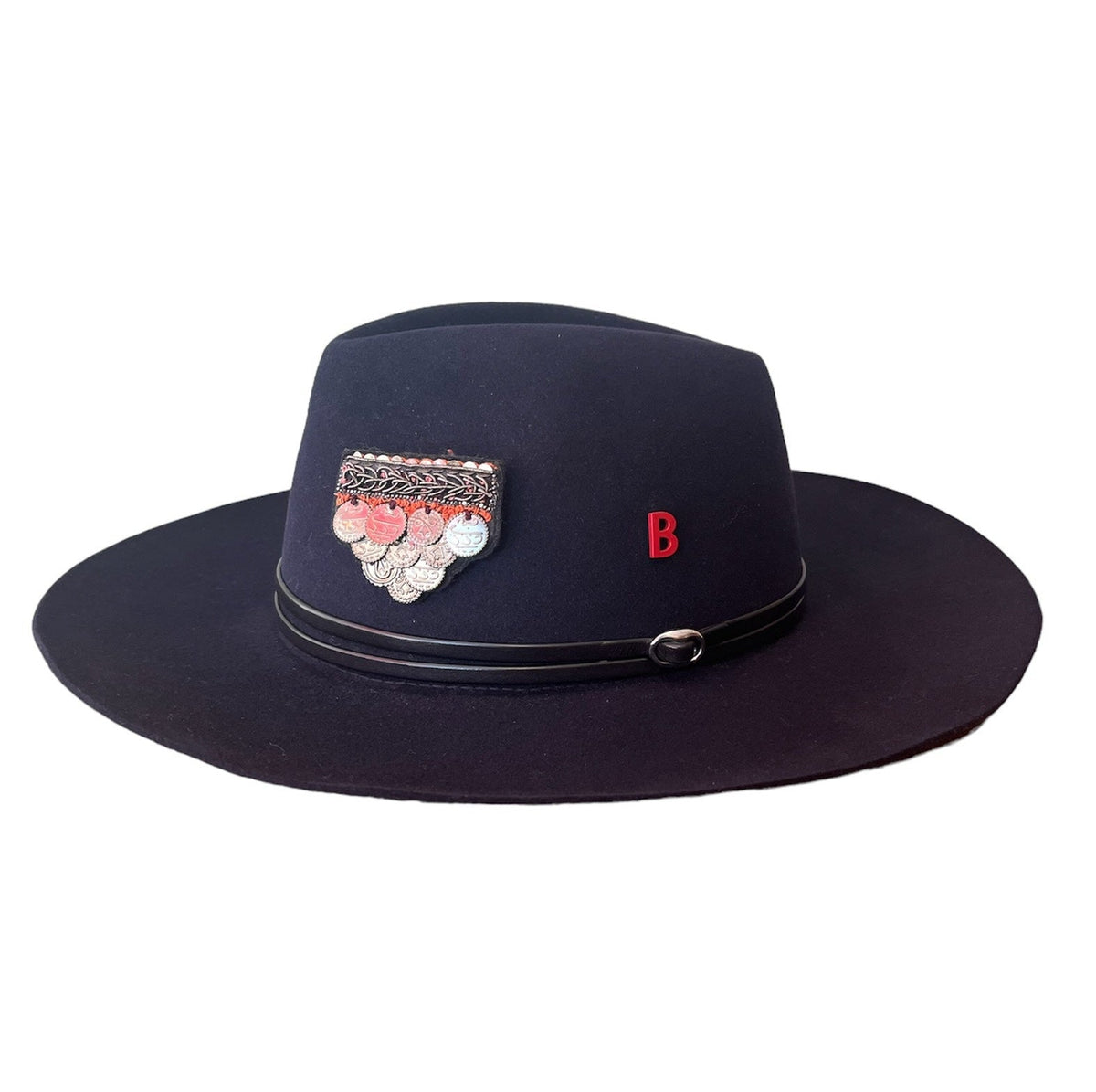 A black wool hat with a leather brim and an embroidered brooch with a feather design on the crown.