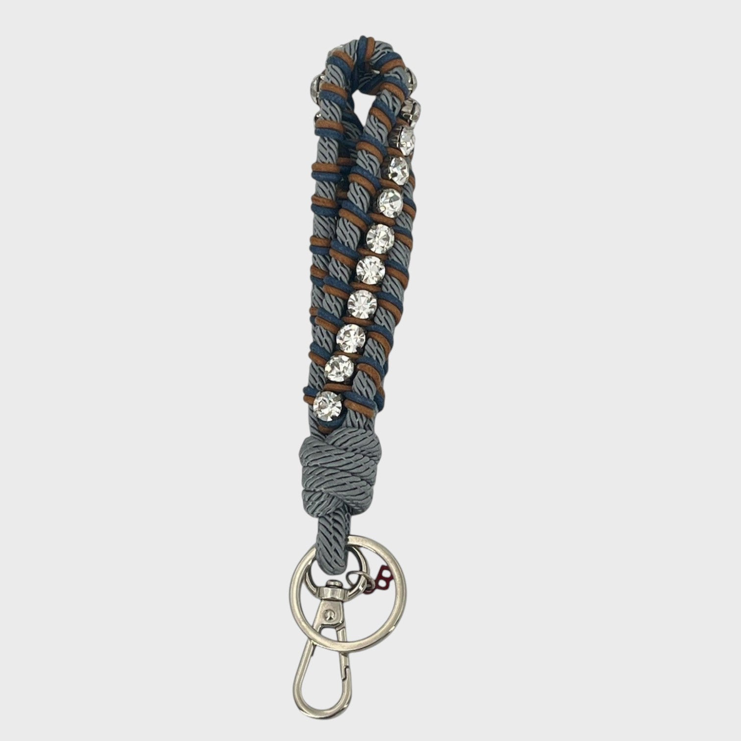 A macramé braided keychain strap featuring a blue and brown pattern, accented with a vertical row of silver rhinestones, and finished with a silver metal lobster clasp on a light gray background.