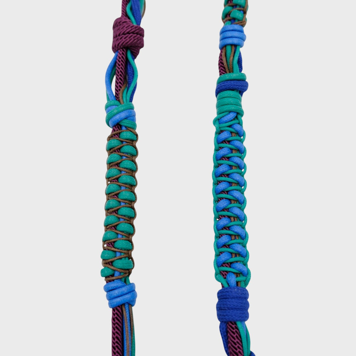 The detail of a green, blue and purple macramé braided phone strap.