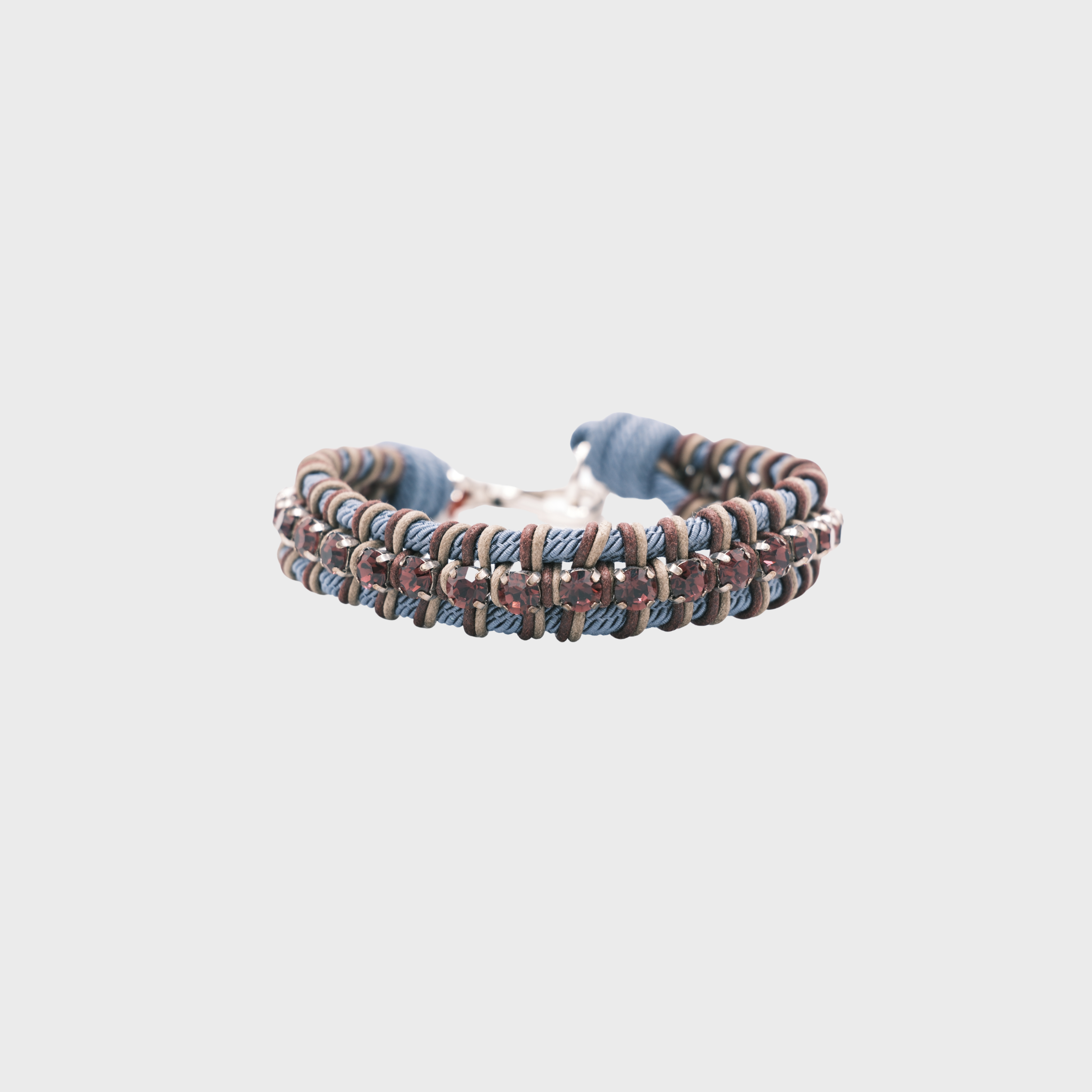 A braided macramé collar featuring blue, brown and beige cords with small purple beads.
