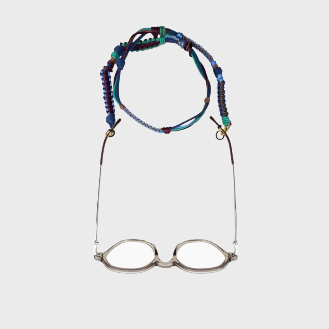 Woven eyeglass holder with purple, blue and green details on a white background