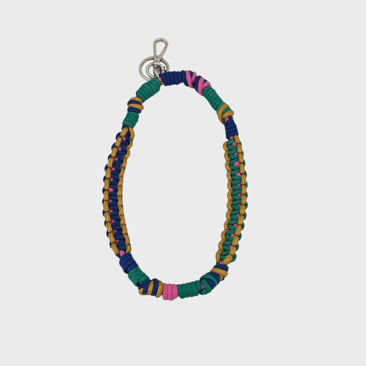 A bohemian-style woven macramé key chain with a silver-tone lobster clasp, featuring dark blue, green, yellow and pink woven segments on a light gray background.