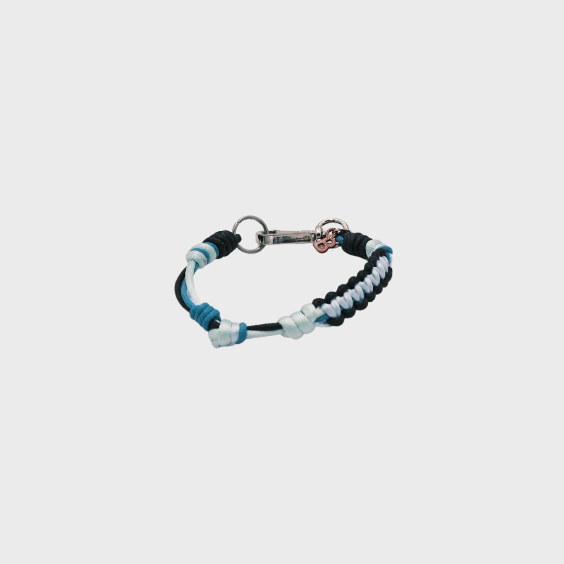 A thin braided bracelet dark and light blue macramé, featuring a silver metal clasp.