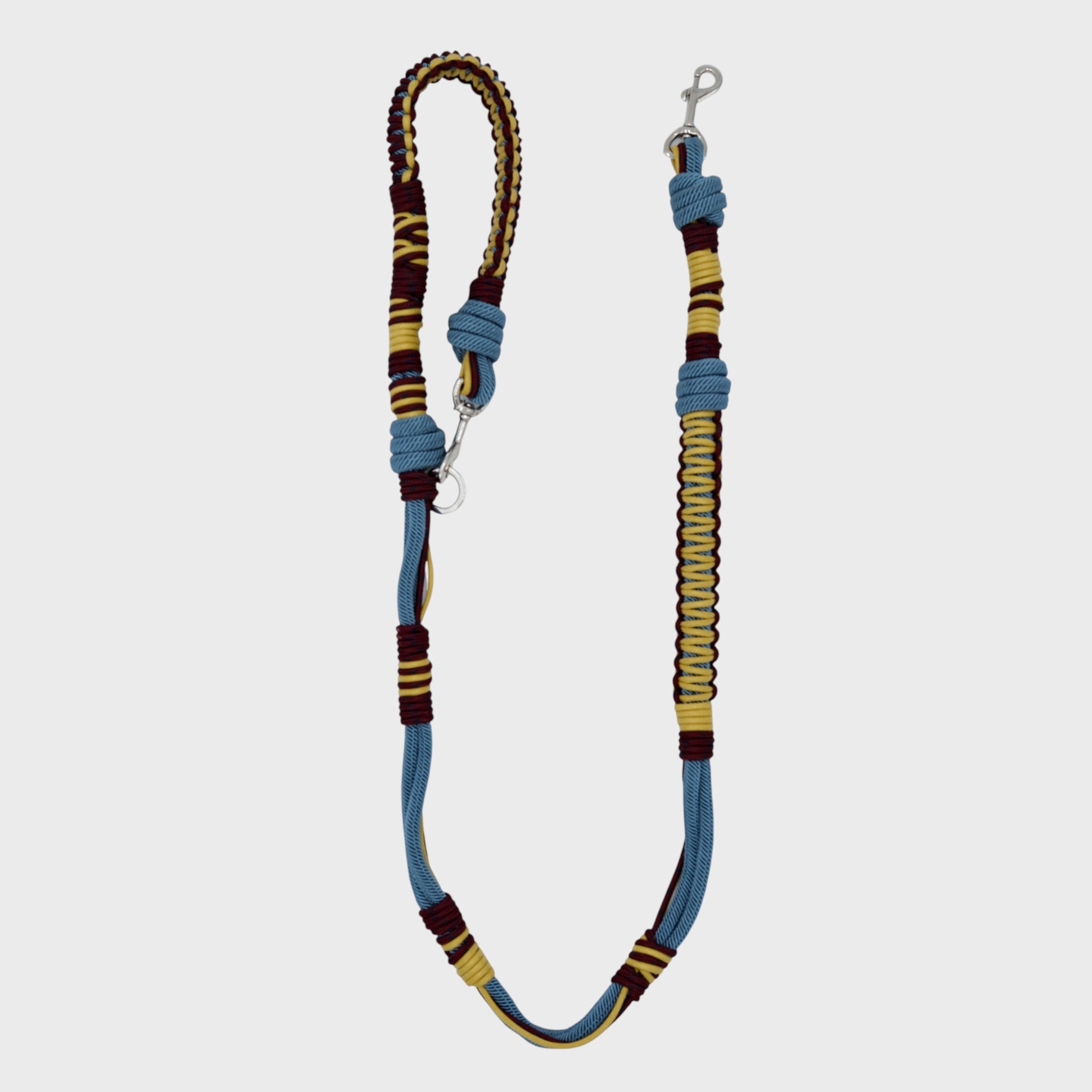 A braided macramé dog leash with blue, yellow and burgundy woven sections, and a silver metal hardware
