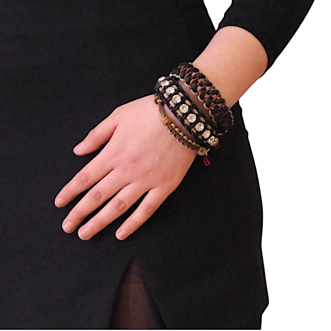 A woman wearing several bracelets including the beige, black and brown Emil bracelet
