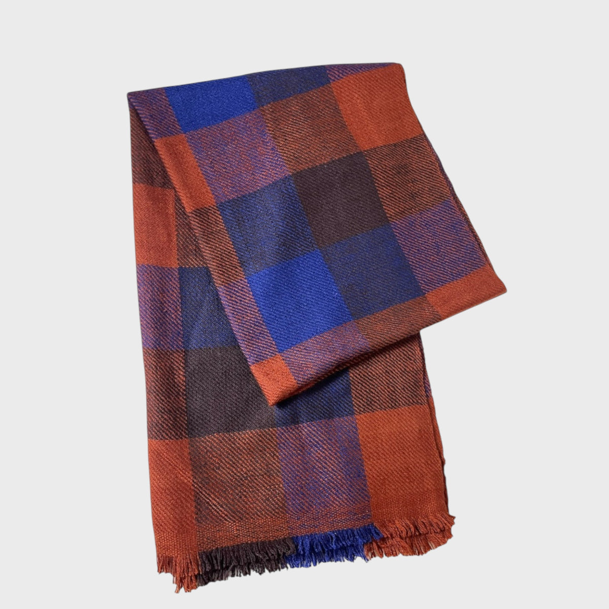 Plaid shawl of scarf with red and blue pattern on a light gray background