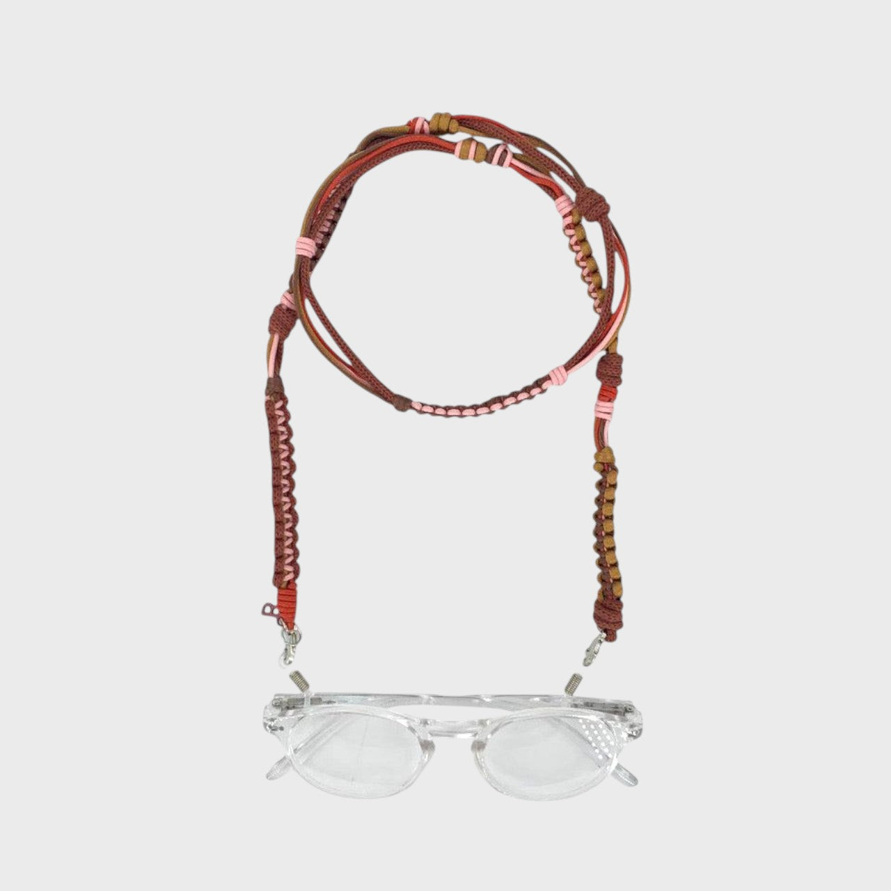 Woven eyeglass holder with brown, light pink and red details on a white background