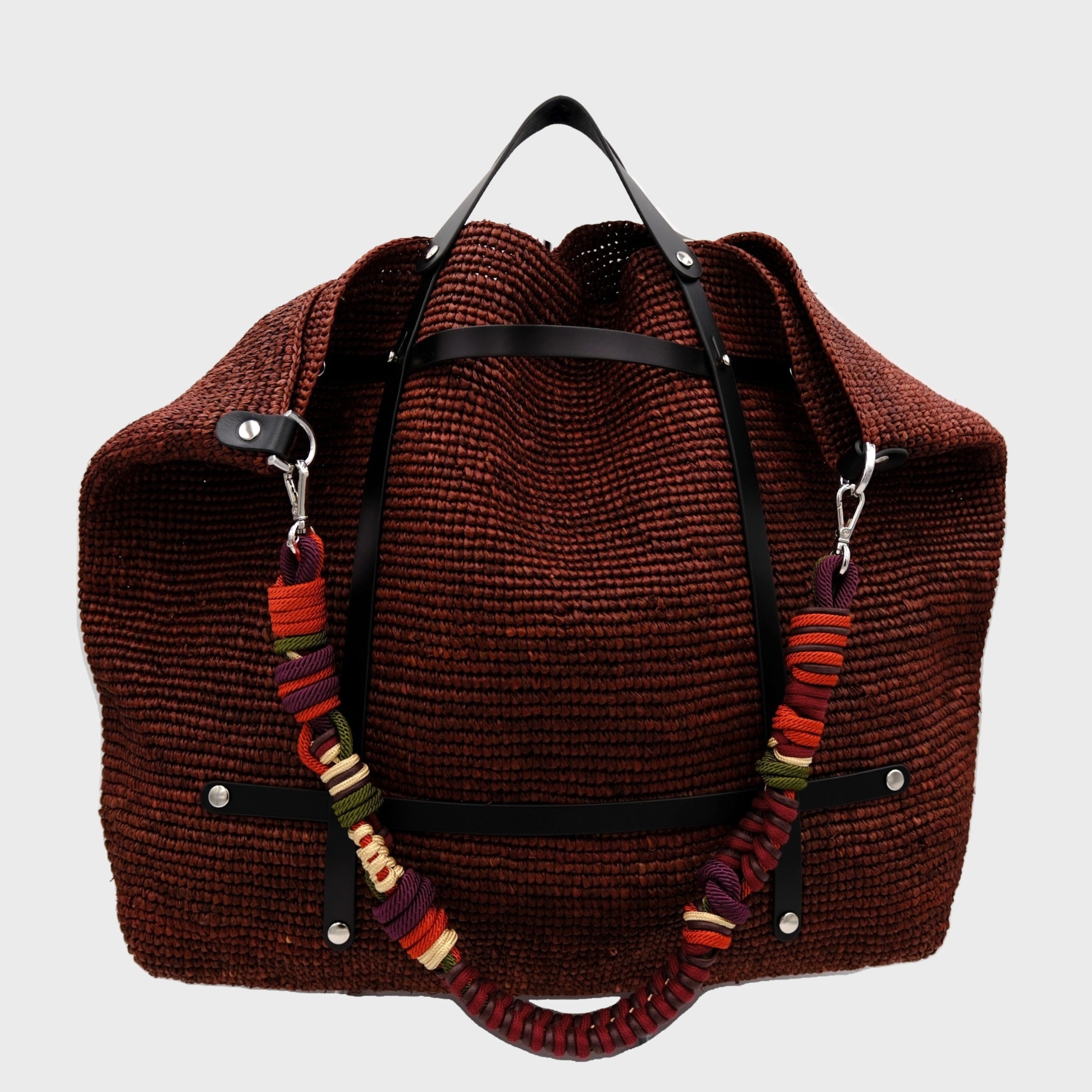 Brown raffia weekend or duffle bag with a colourful shoulder strap in red, green and aubergine.