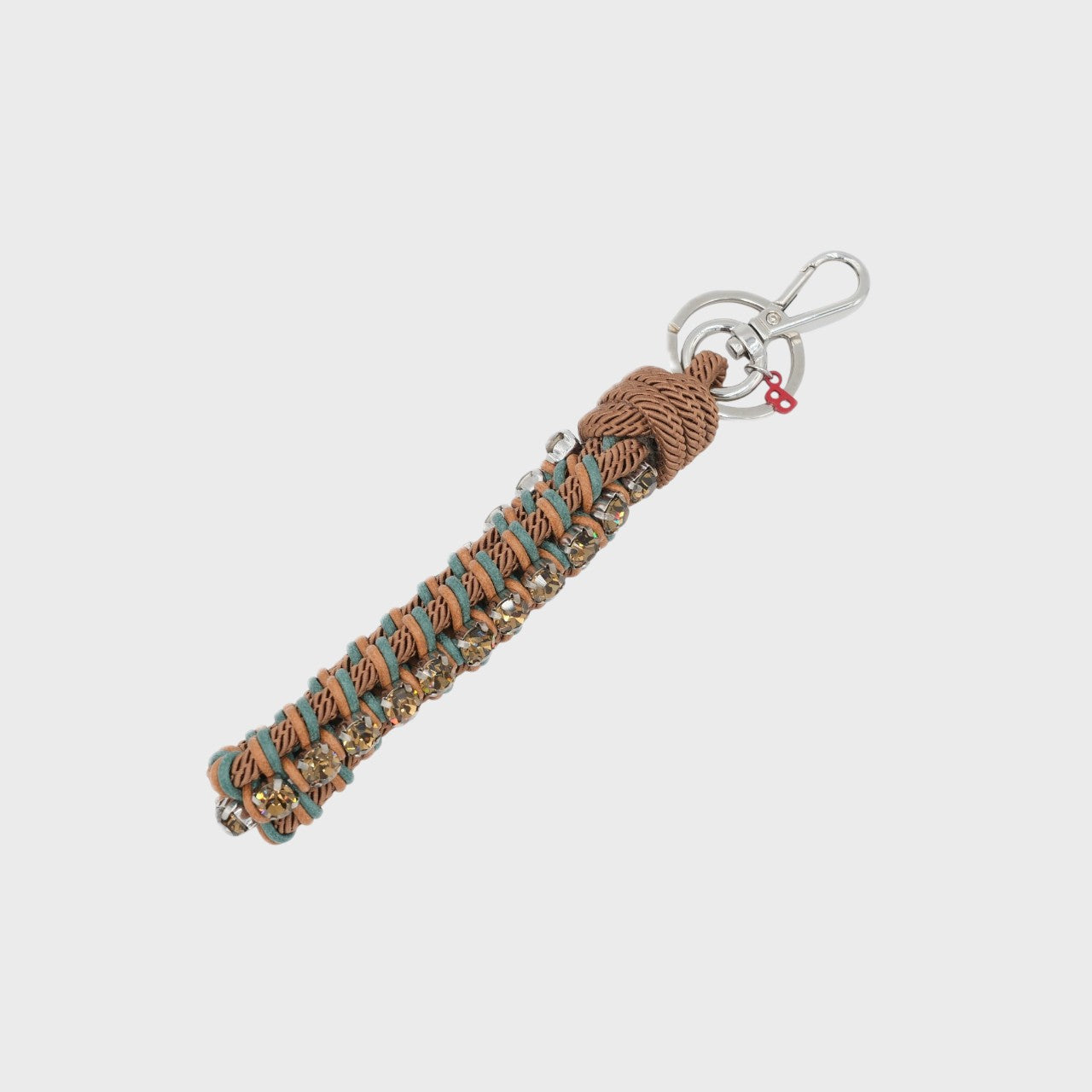 Keychain with brown and dark green patterned band and rhinestones on a white background