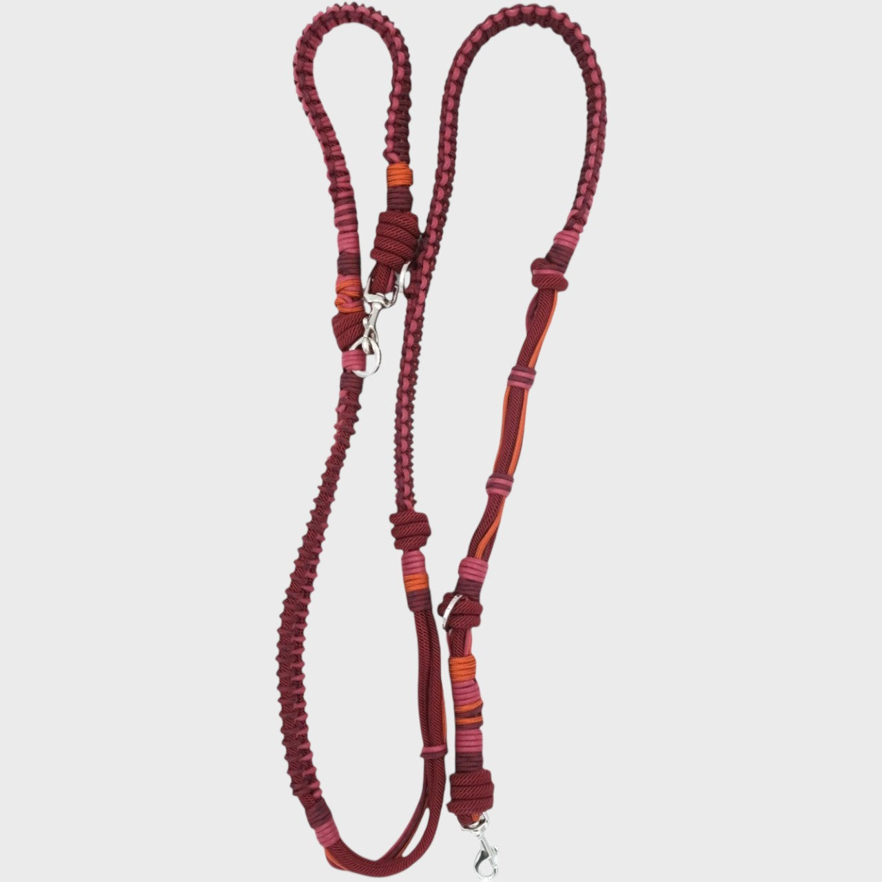 A braided macramé dog leash with burgundy and orange woven sections, and a silver metal hardware.