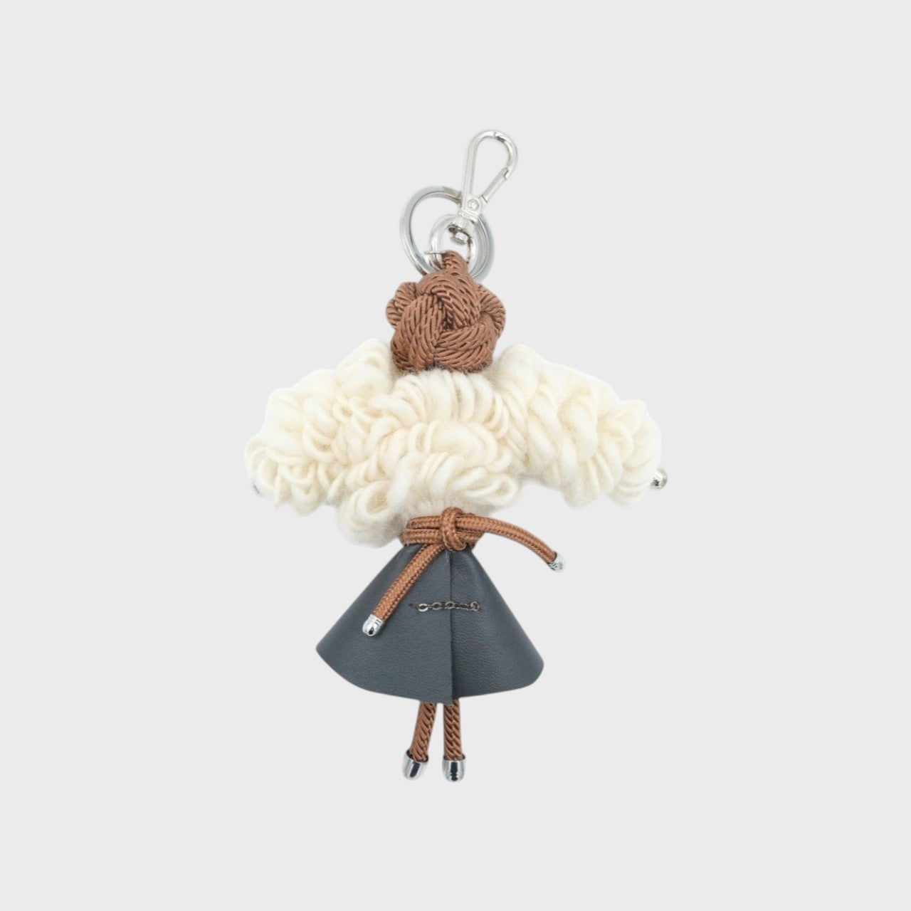 CATHERINE character key charm wears a grey leather skirt, a macramé cord belt and soft cream wool hair