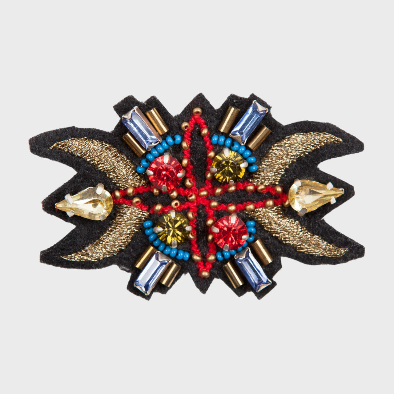 An embroidered brooch representing a sunset horn with blue, red and golden details.