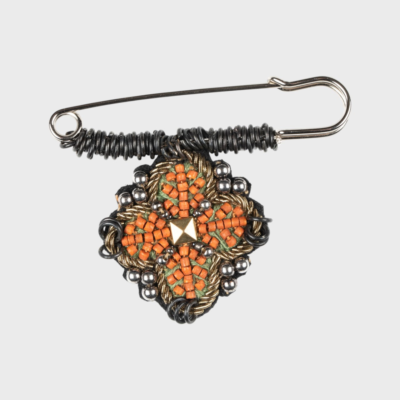 An embroidered pin with orange and green details.