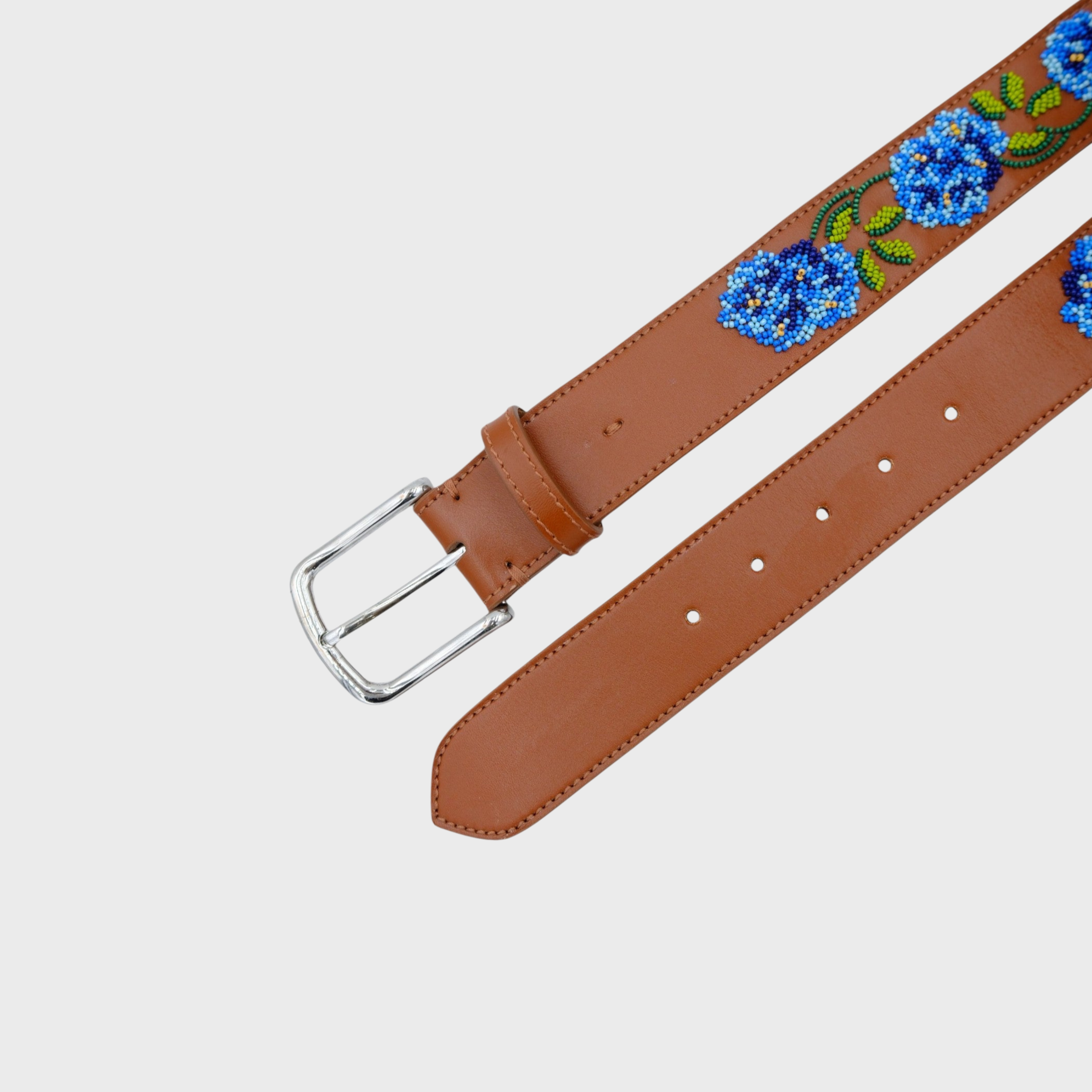 A brown leather belt with a silver buckle, featuring embroidered blue flowers and green leaves along the strap.