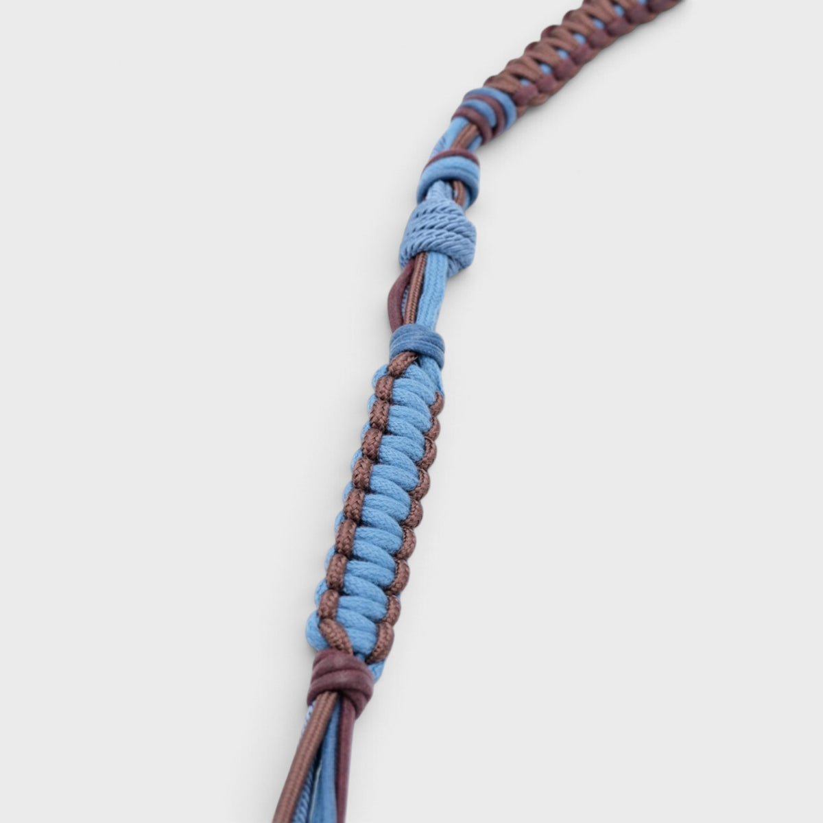 A detail of a macramé blue and chocolate bag strap.