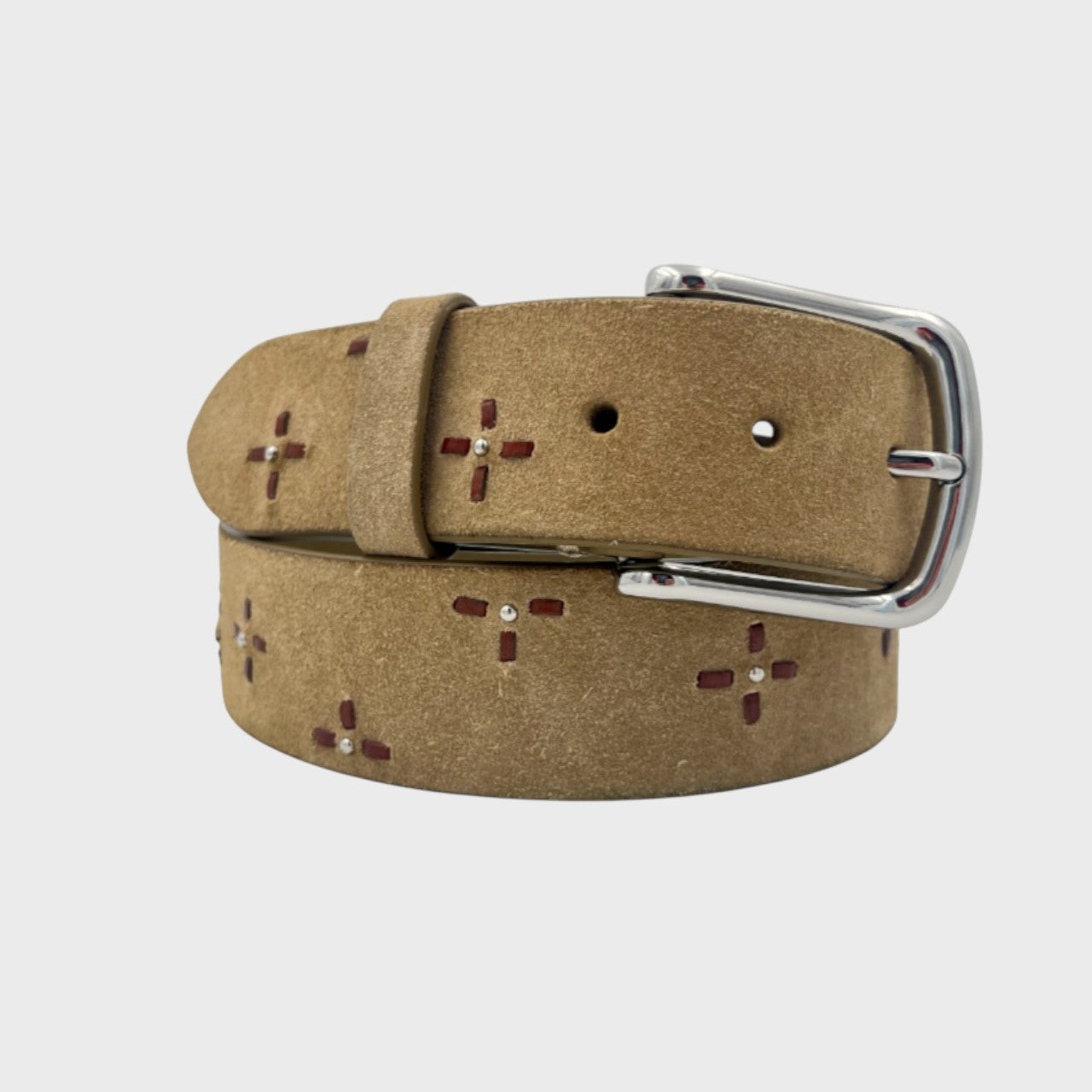 Close-up of a beige suede belt with decorative flowers and a silver buckle.