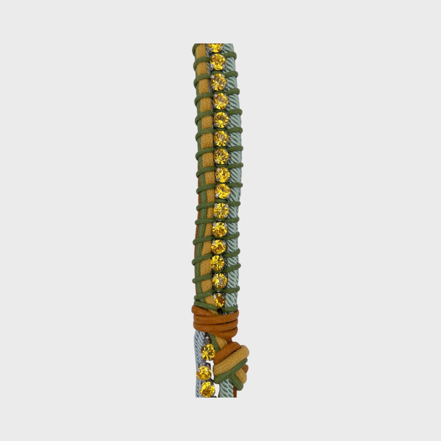 Clos up of the multicolored braided macramé bag strap in blue, yellow and green featuring some yellow colored beads and shown on a light grey background.