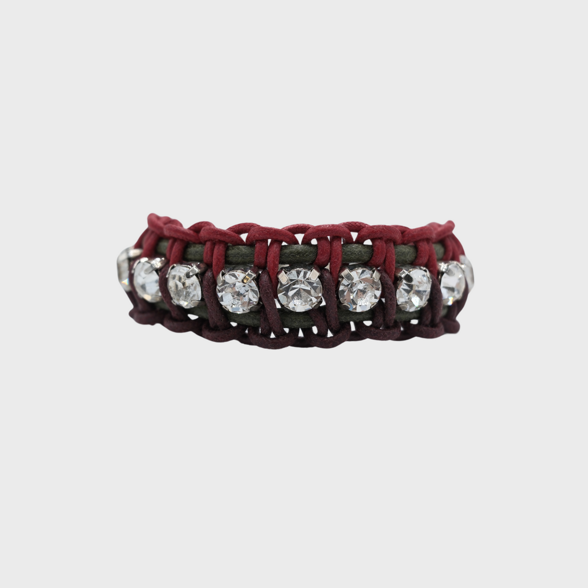 A handmade macramé woven bracelet featuring a mix of brugundy, green and red threads, accented with small white beads and a silver clasp.