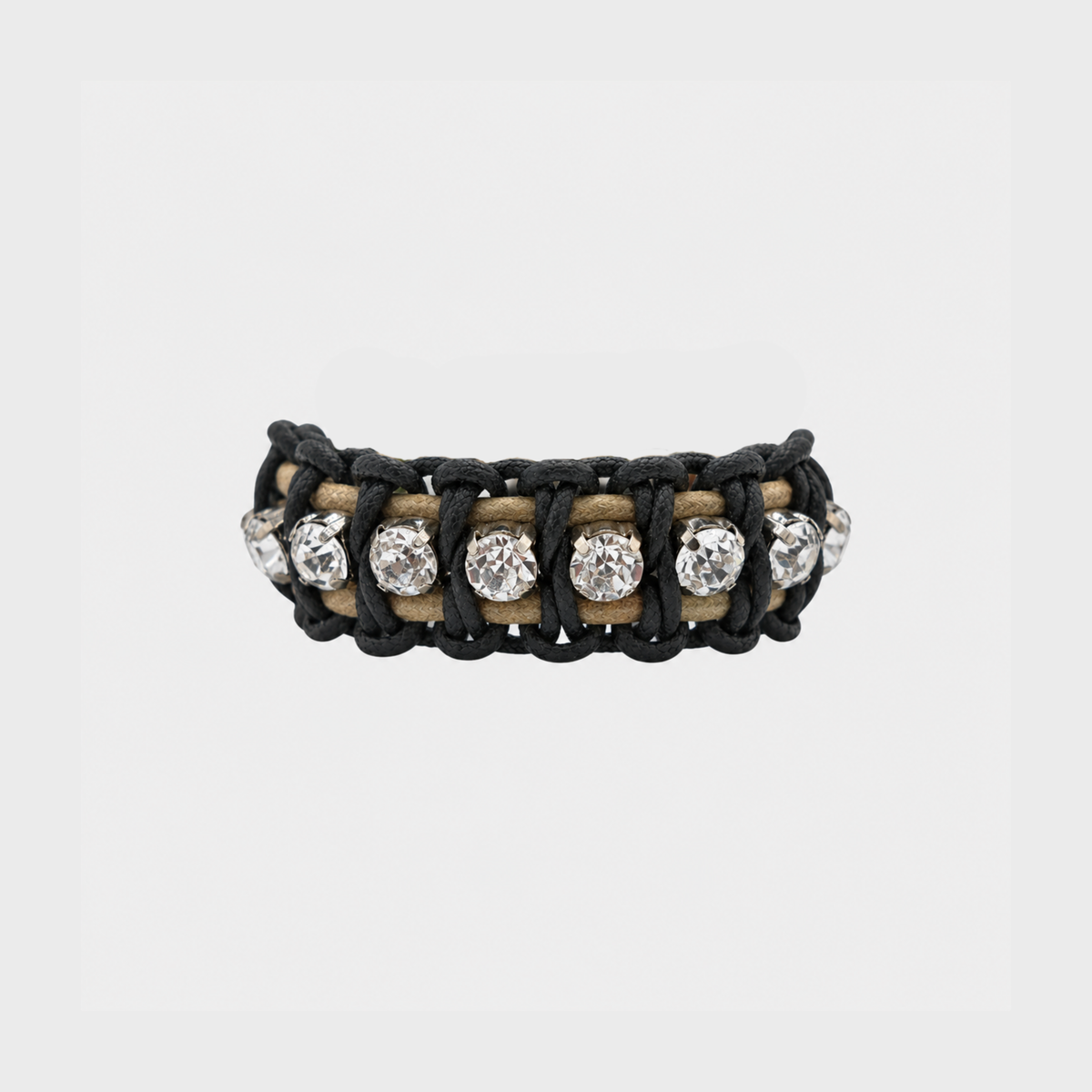 A black woven cord bracelet featuring round clear rhinestones set in a light beige band, shown against a plain light gray background.