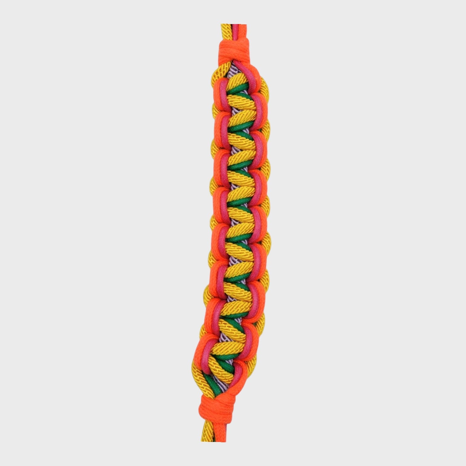 Close up of the multicolored braided macramé bag strap in yellow, lilac, orange, and green shown on a light gray background.