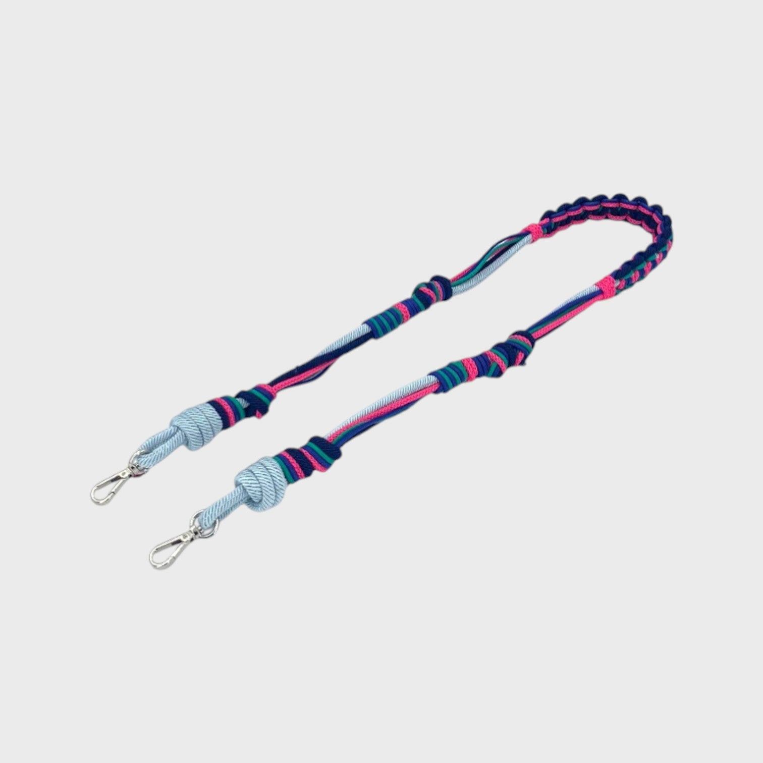 Multicolored braided macramé bag strap in bright pink, bright blue, and light blue with metal hooks on a light gray background.