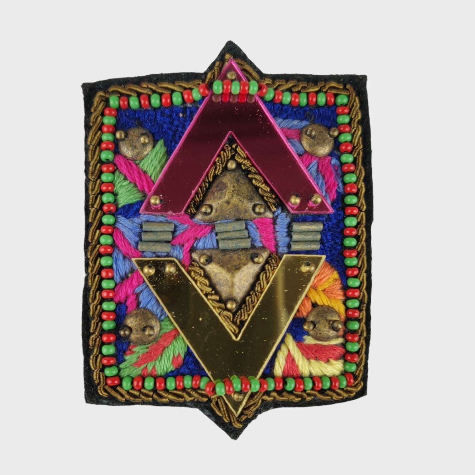An embroidered brooch representing the elements.