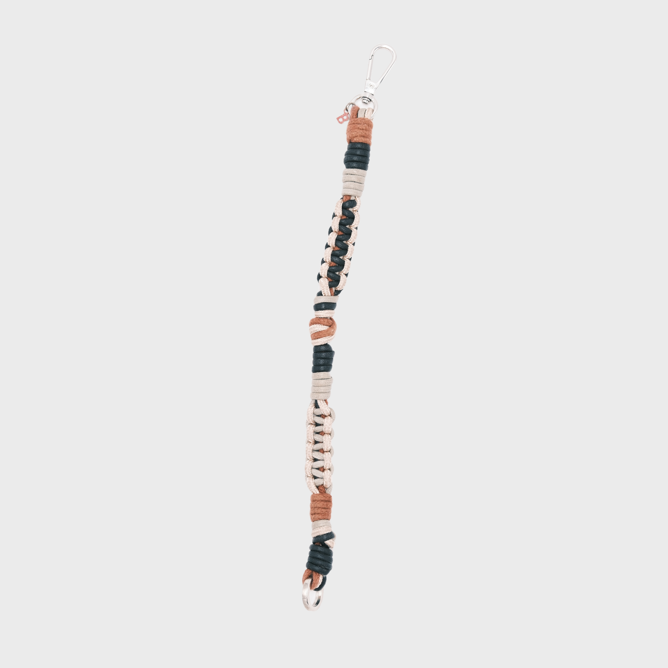 A handmade braided macramé cord collar in white, beige, black and brown with a silver clasp.