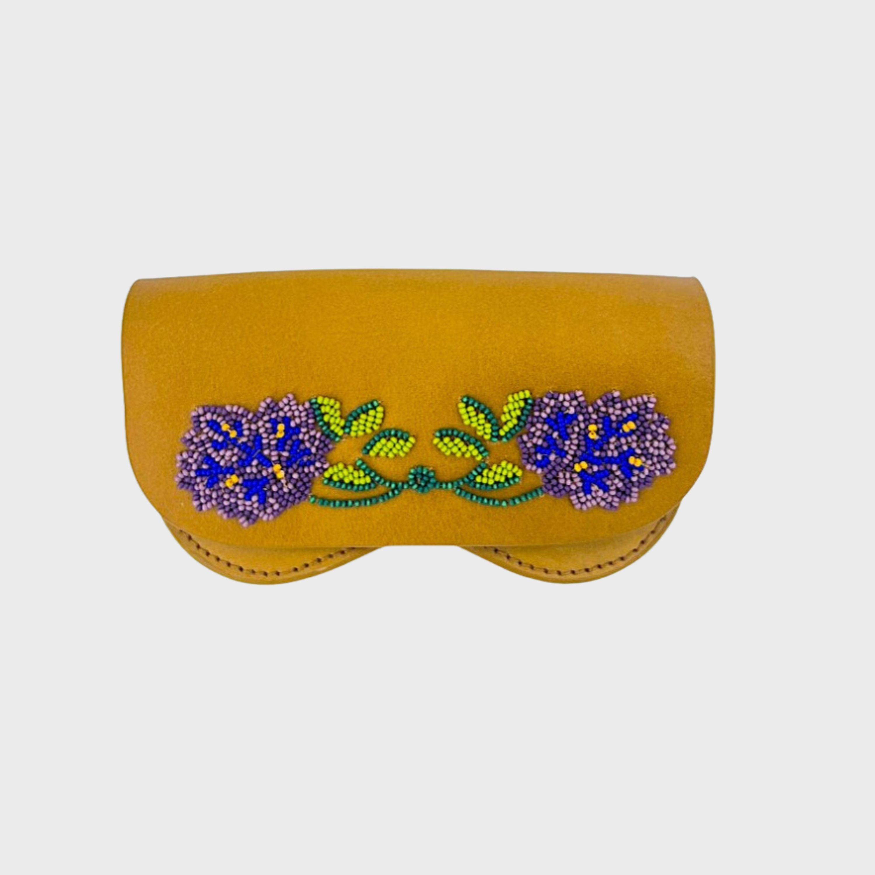 A mustard yellow leather glasses case featuring a decorative embroidered floral design across the front with purple flowers and green leaves, set against a light gray background.