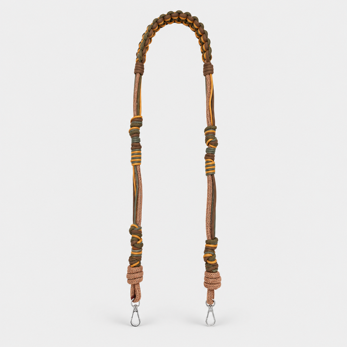 Brown and green macramé woven long bag strap with metal clasps on a light gray background