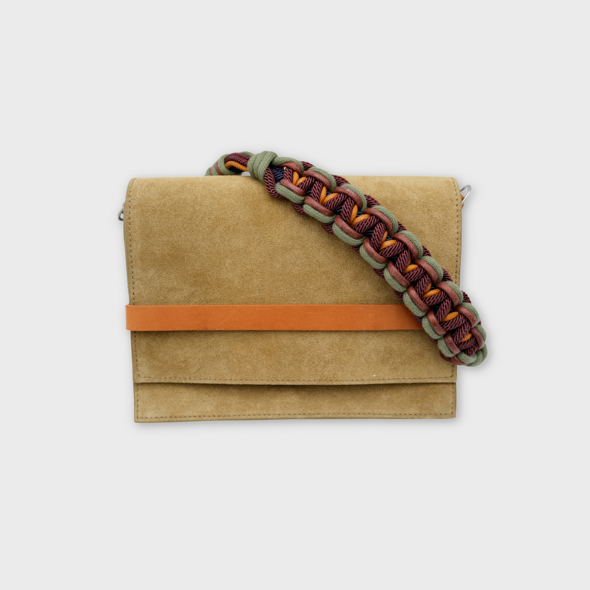 A green suede crossbody bag with a vibrant multicolor woven strap and a horizontal orange-brown leather accent band across the front, shown against a light gray background.