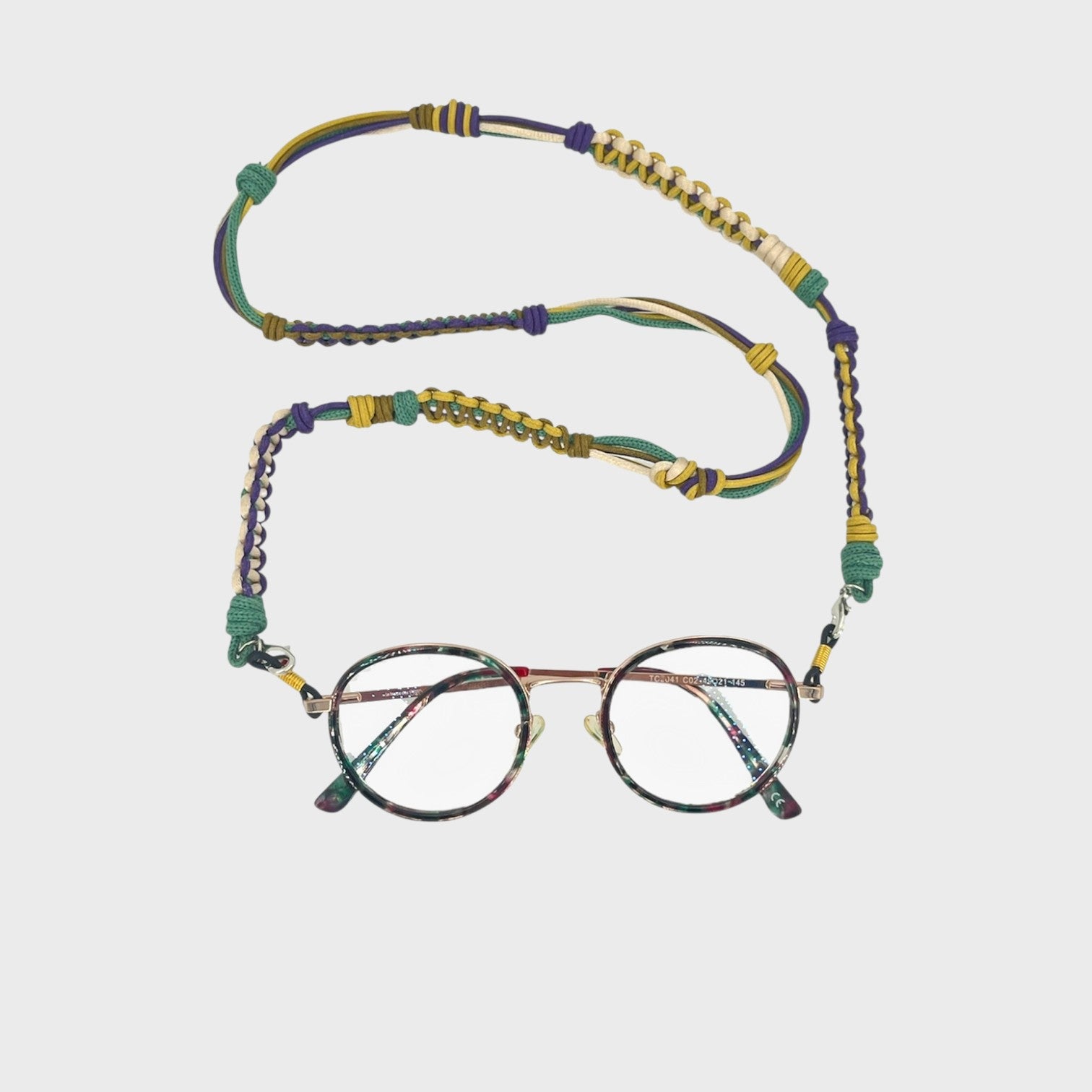Woven eyeglass holder withyellow, green, purple and beige details on a white background