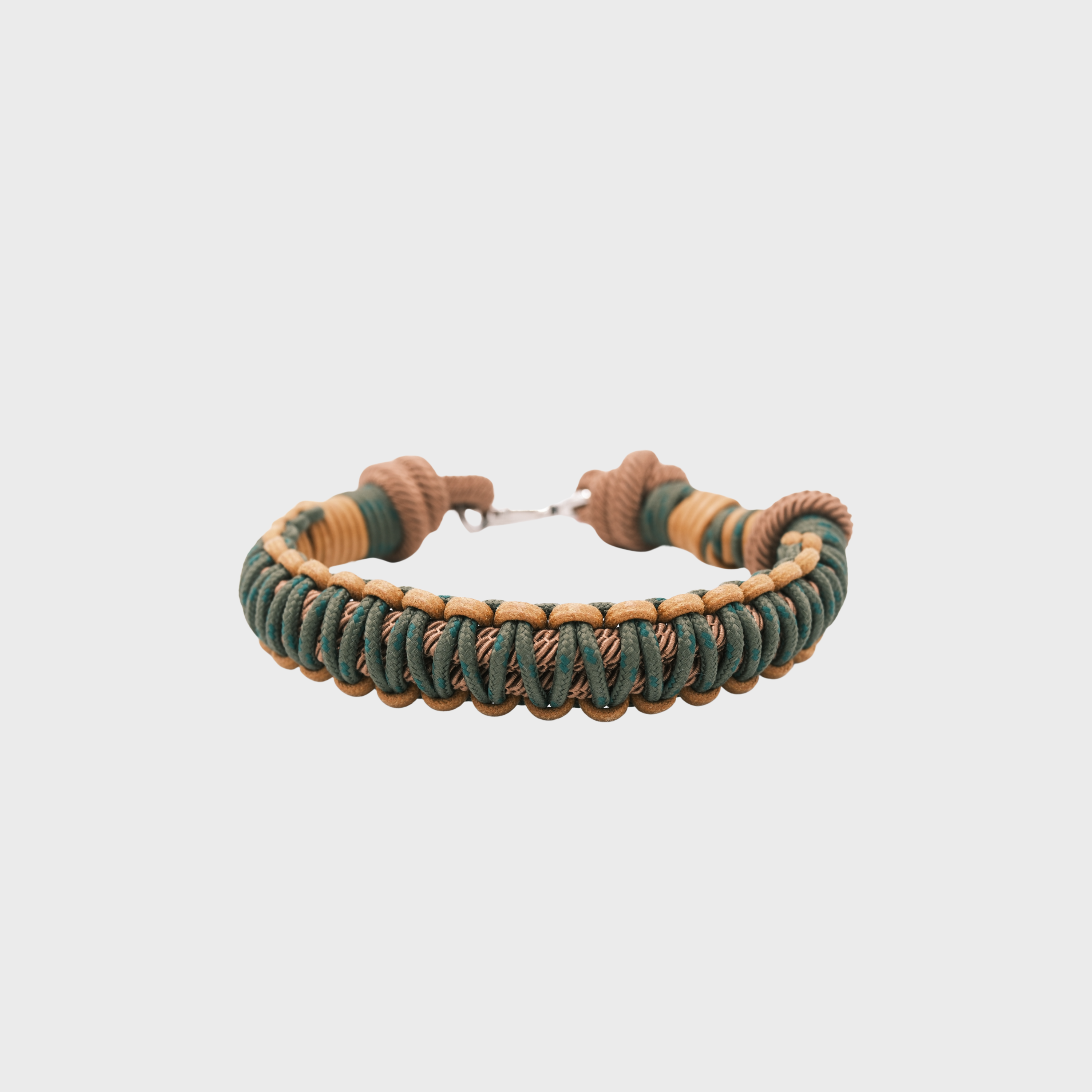 A braided macramé cord collar in shades of dark green and yellow with a silver clasp, centered on a light gray background.