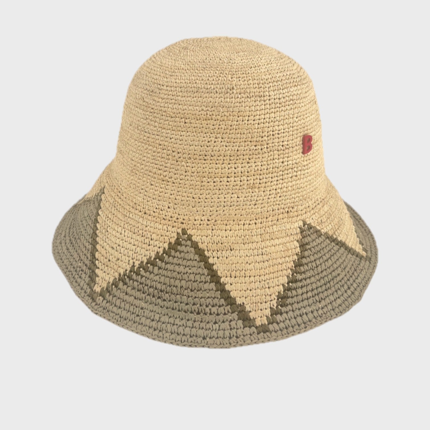 Two-toned raffia bucket hat with grey-blue and beige accents on a light gray background
