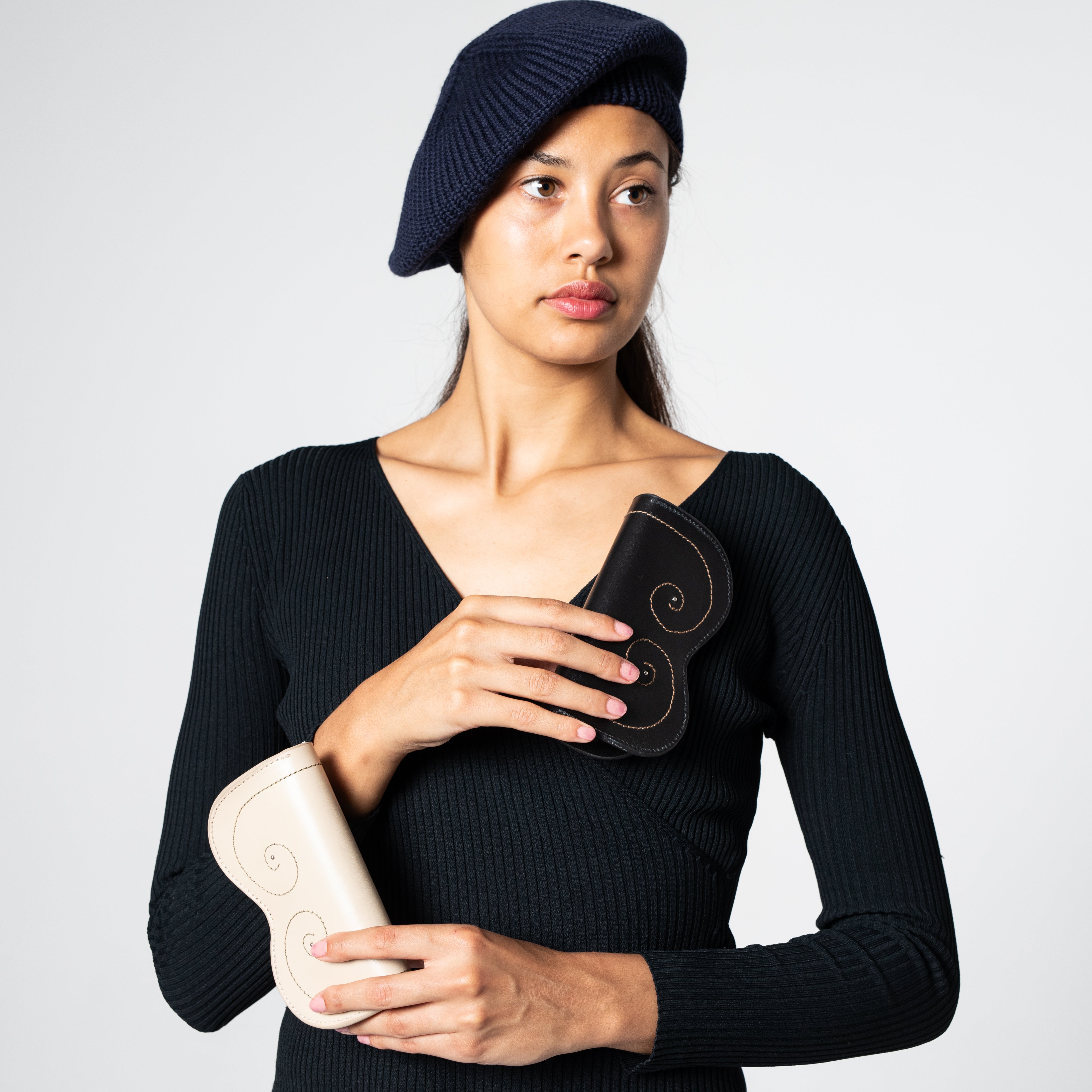 A model carrying two glasses cases including the white Growth one.