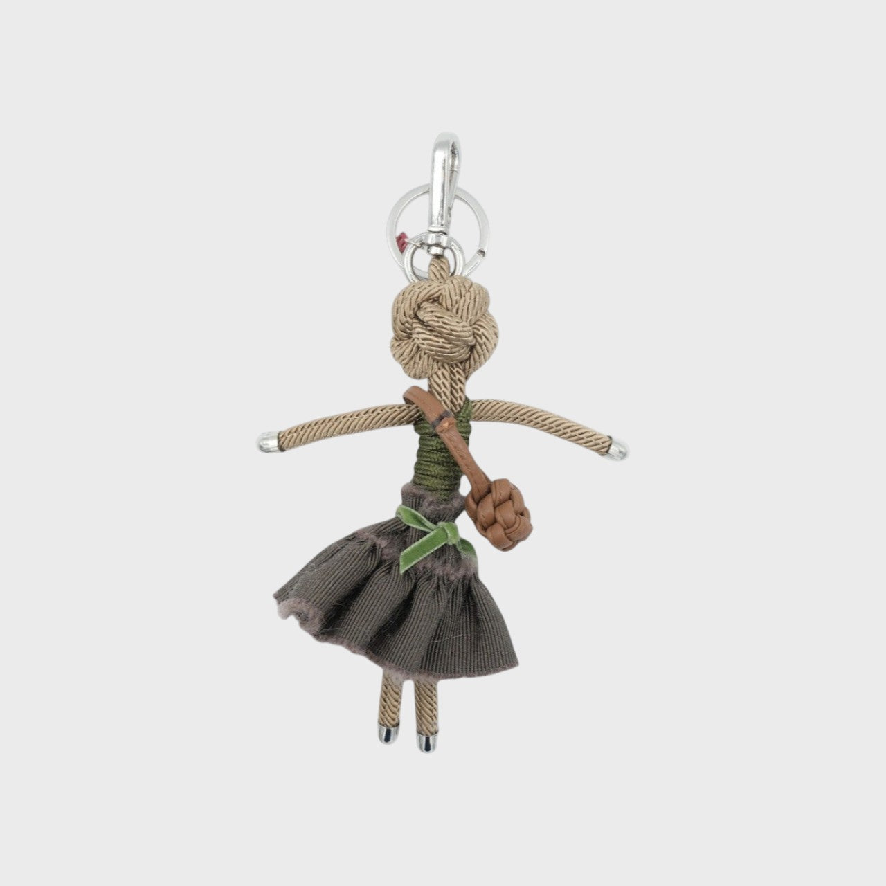 ISABELLE character key charm wears a dark brown skirt with a green velvet ribbon and carries a mini cognac bag, her hair crafted from macramé cord for a playful, creative touch.