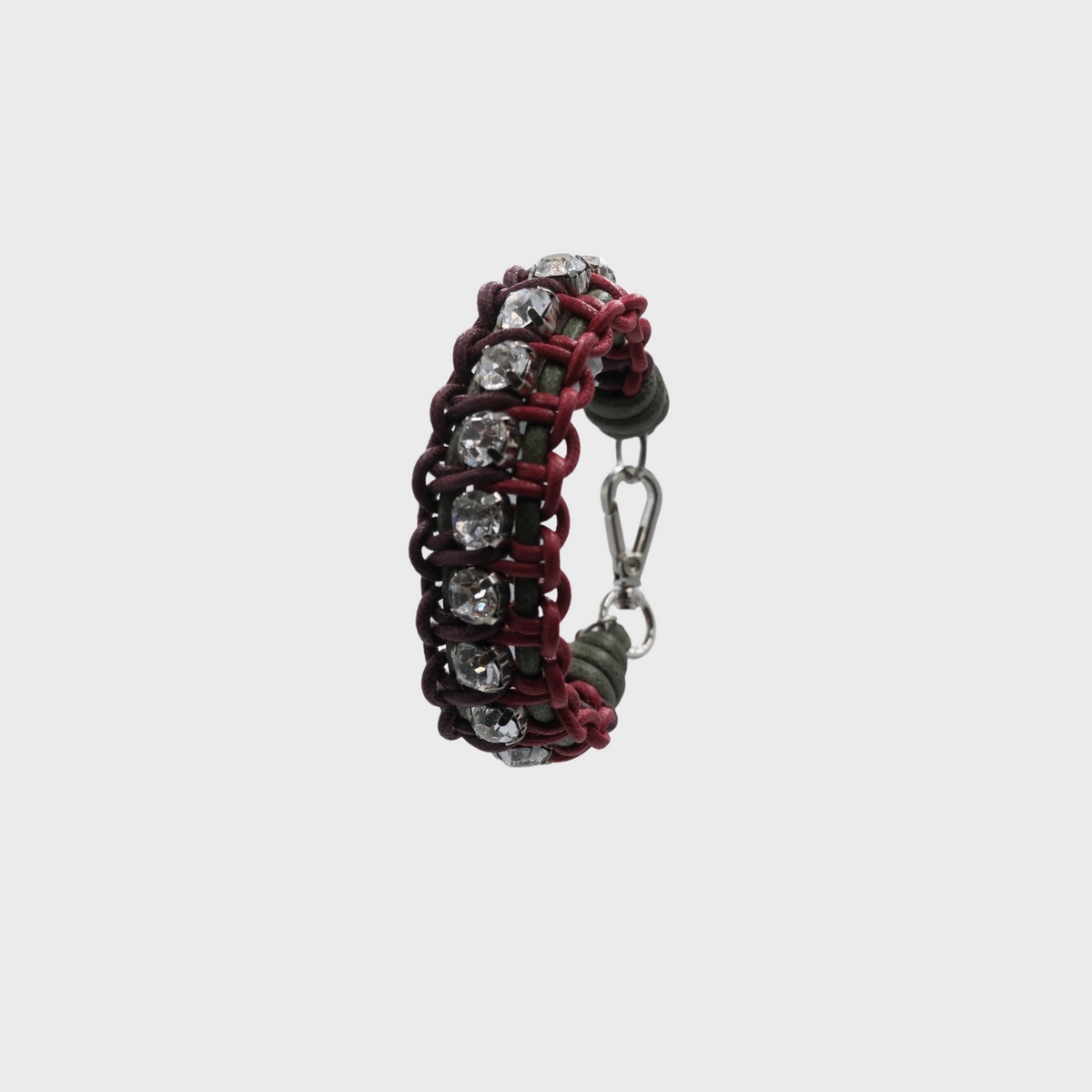 A braided macramé bracelet featuring green, burgundy and red cords with small white beads.