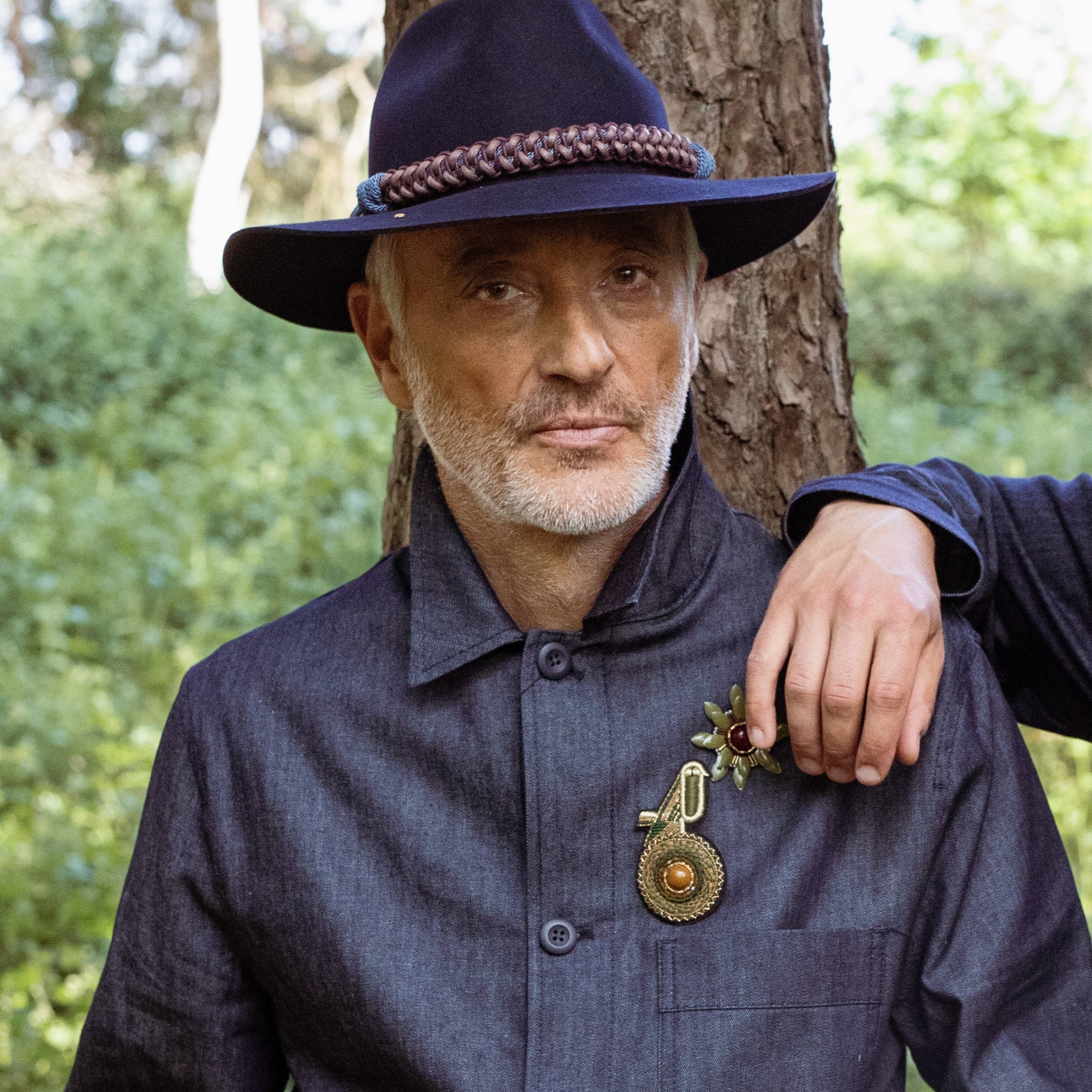 A model wearing a green kiwi bird brooch.