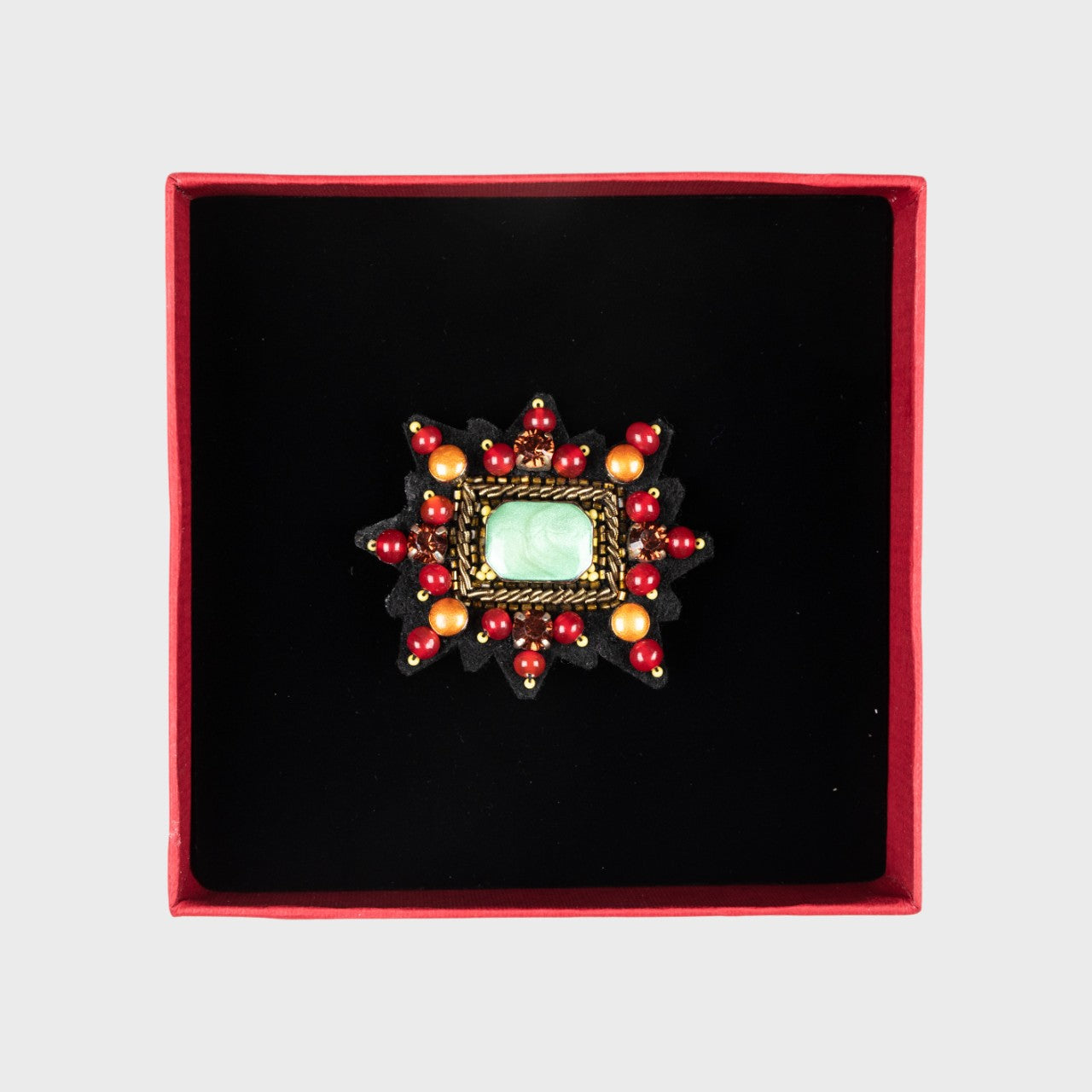A red Mizar star brooch in a box.