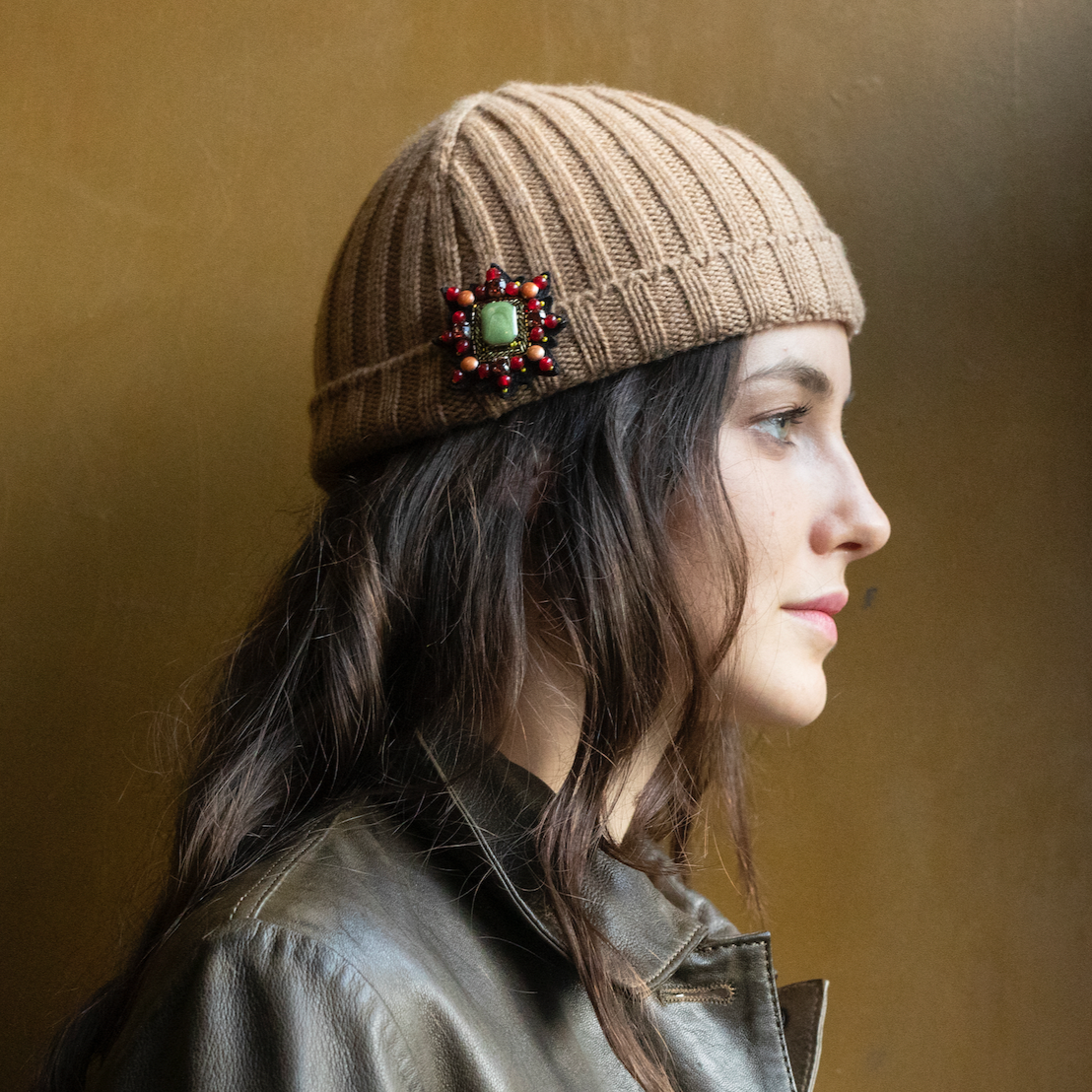 A model wearing on her winter hat the red Mizar star brooch.