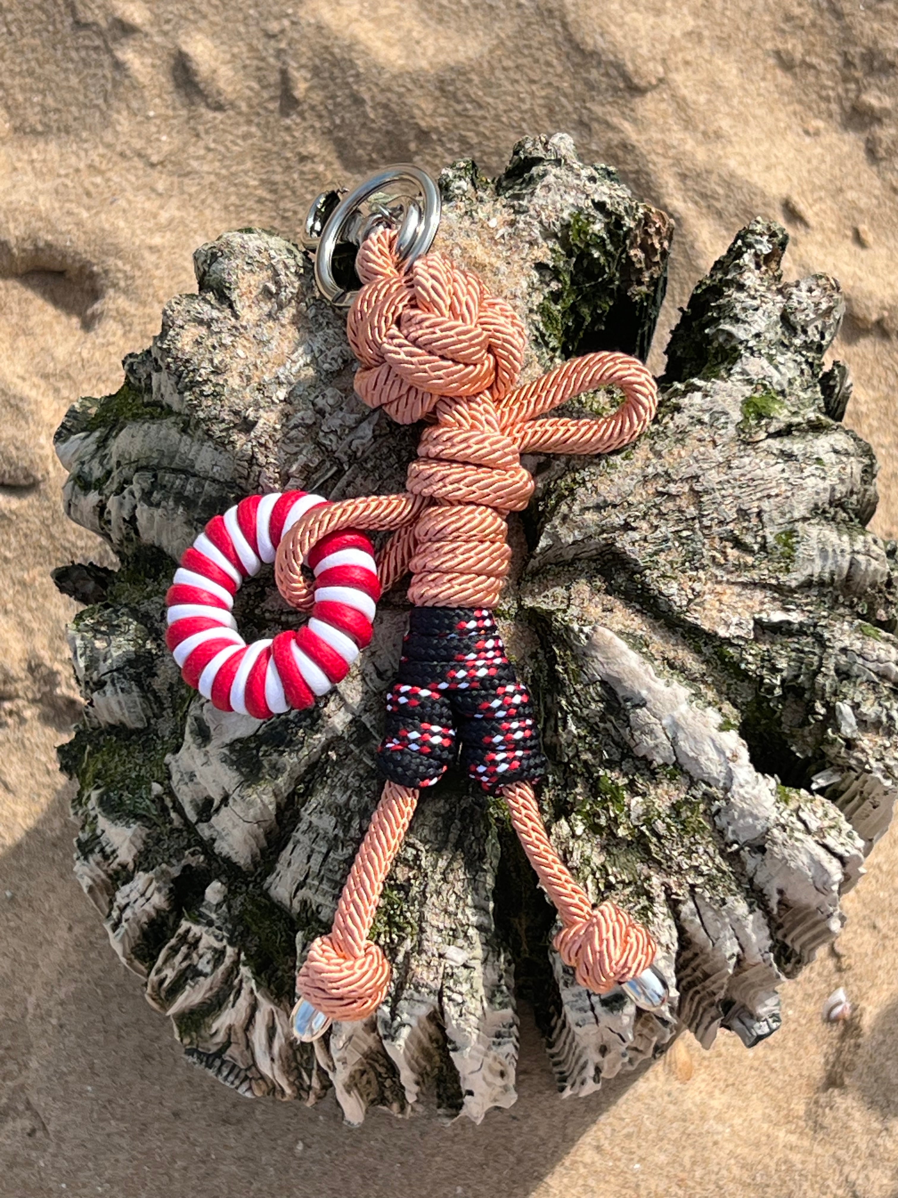 Arthur bag charm shown here on the sandy beach on a sunny day