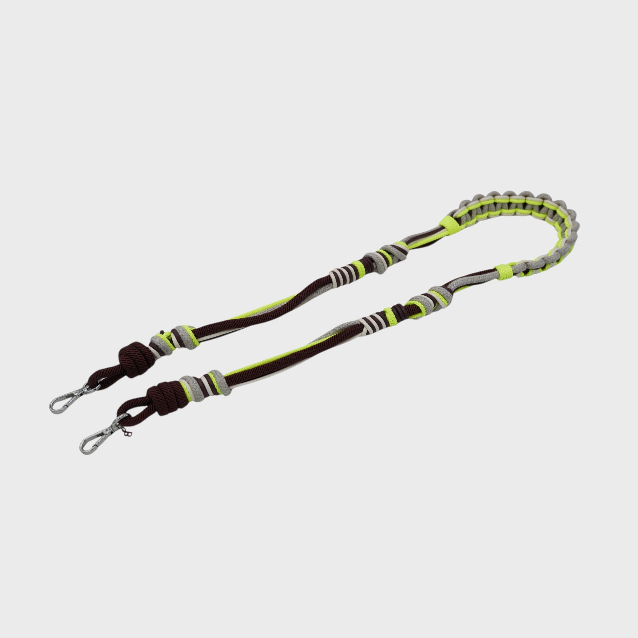 Multicolored braided macramé bag strap in neon yellow, beige, and brown shown on a light gray background.
