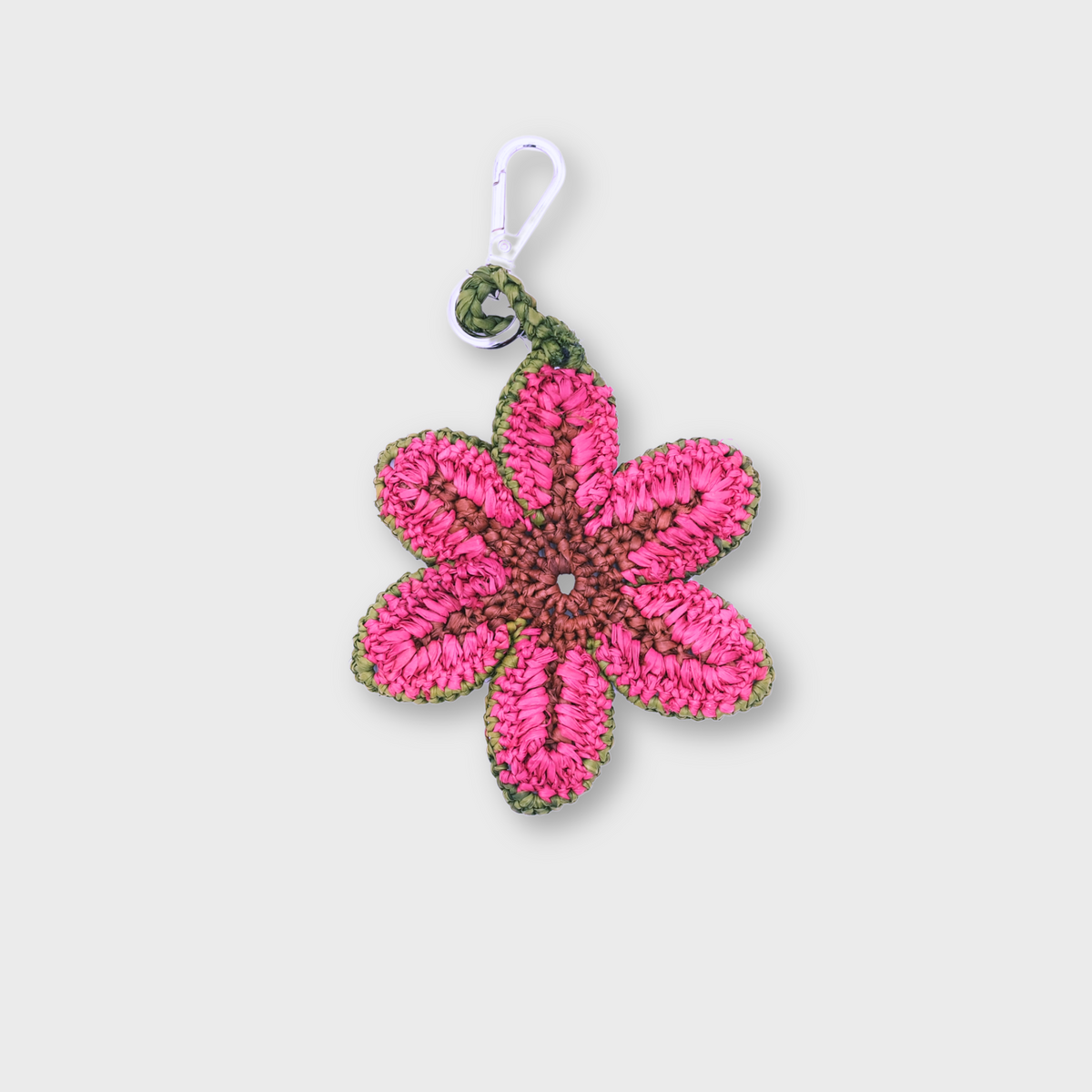 A raffia pink bag charm representing a flower.