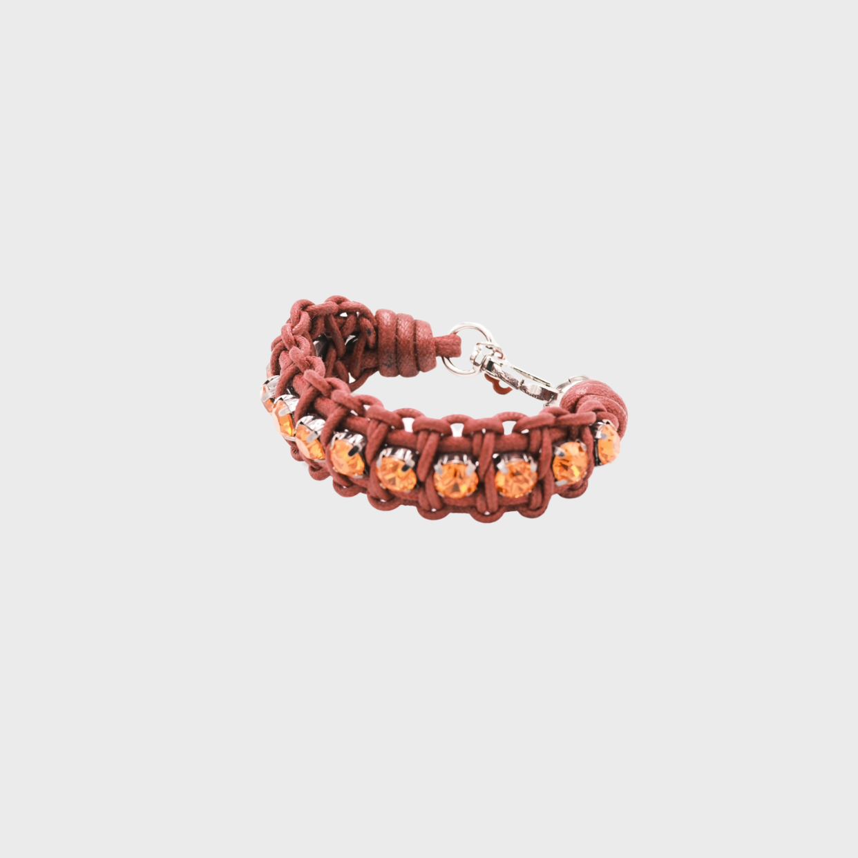 A braided macramé bracelet featuring pink cords with small orange beads.