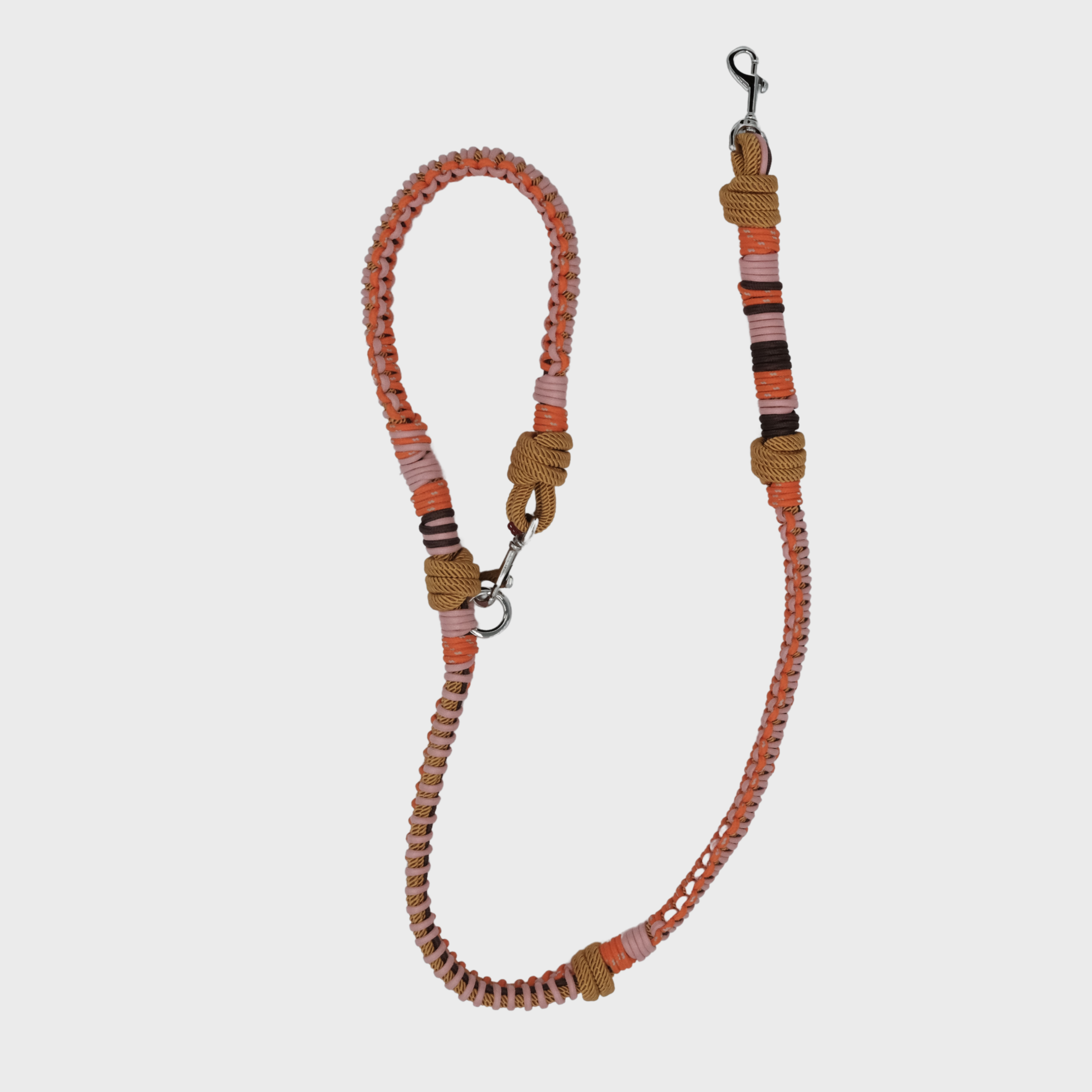 A braided macramé dog leash with light pink and orange woven sections, and a silver metal hardware